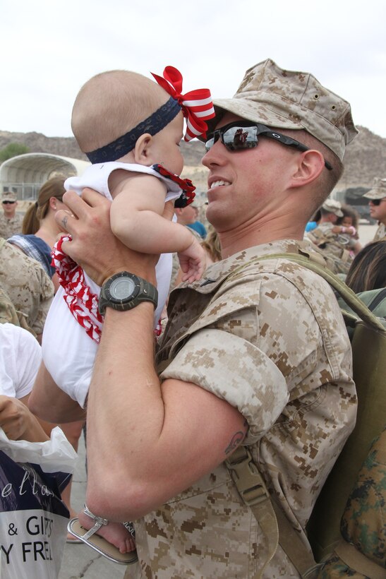 Lance Cpl. Anthony Walsh, a rifleman with 3rd Light Armored Reconnaissance Battalion, holds for the first time his 4-month-old daughter, Mya, during homecoming celebrations at the battalion’s motor transport lot June 1, 2011. Mya was born while Walsh was deployed for seven months to Afghanistan.