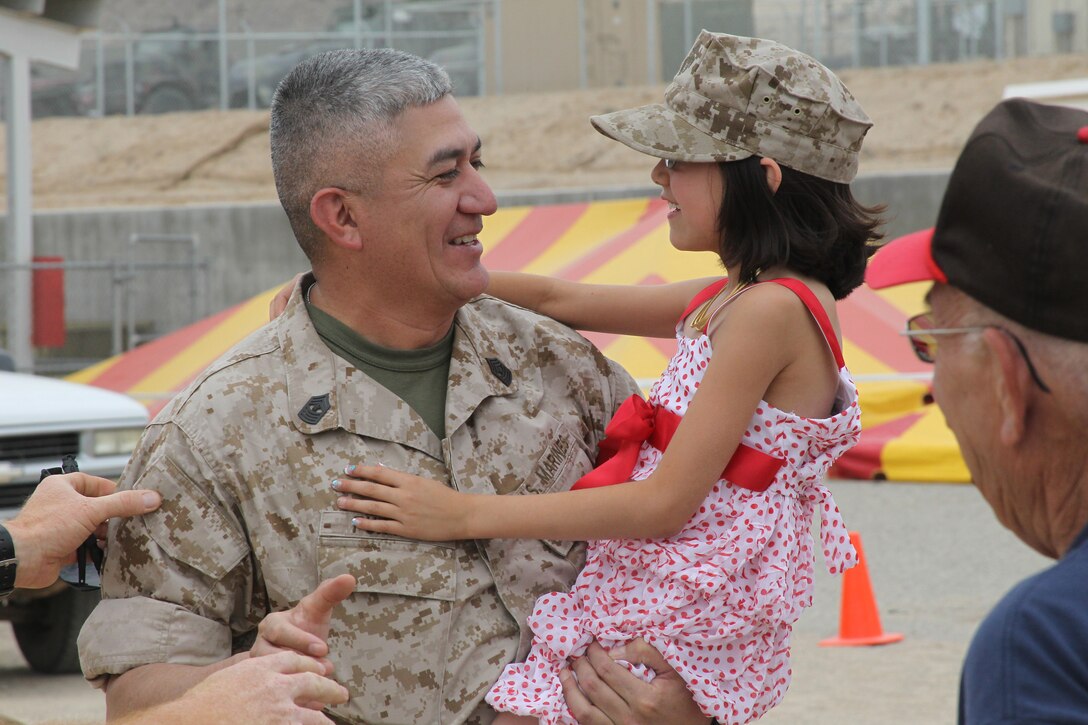 Master Gunnery Sgt. Victor Purvis, a battalion motor transport chief with 3rd Light Armored Reconnaissance Battalion, holds his 7-year-old daughter, Reagan, moments after returning from a seven-month long deployment to Afghanistan June 1, 2011.