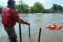 MINOT, N.D. – Larry Rutschke, U.S. Geological Survey, hydrological technician, measures the flow of water June 1 In preparation for possible flooding, as Airmen from Minot Air Force Base, North Dakota National Guard as well as many other organizations, are setting up secondary dikes along the river. The Souris River threatens to break the levies already in place, thousands of Minot citizens, including military members, their families and DoD civilians, have been forced to evacuate the area.  (U.S. Air Force photo/Senior Airman Jesse Lopez)