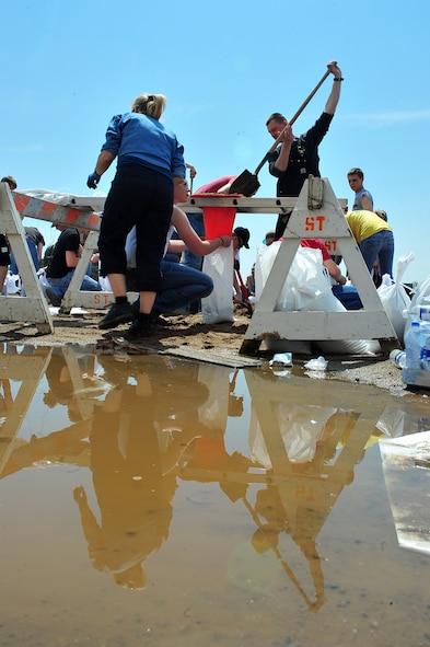 MINOT, N.D. -- Members of Team Minot work together to make sandbags at the Minot Public Works June 1 In preparation for possible flooding, the city of Minot, with assistance from Airmen from Minot Air Force Base, North Dakota National Guard as well as many other organizations, are setting up secondary dikes along the river. The Souris River threatens to break the levies already in place, thousands of Minot citizens, including military members, their families and DoD civilians, have been forced to evacuate the area.  (U.S. Air Force photo/Senior Airman Jesse Lopez)