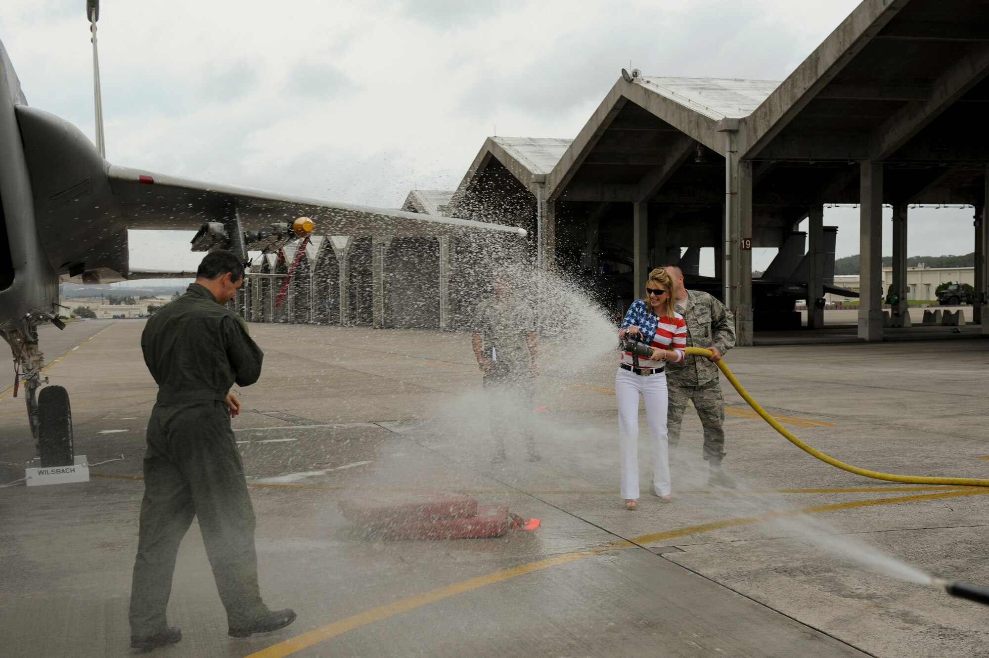 Cindy Wilsbach hoses down her husband Brig. Gen. Ken Wilsbach, 18th Wing Commander, after he landed from his “fini-flight” on an F-15 Eagle, June 1. General Wilsbach is preparing to leave Kadena and assume the position of Deputy Director for Operations, Headquarters United States Pacific Command, Camp H.M. Smith, Hawaii. (U.S. Air Force photo/Airman 1st Class Brooke P. Beers)