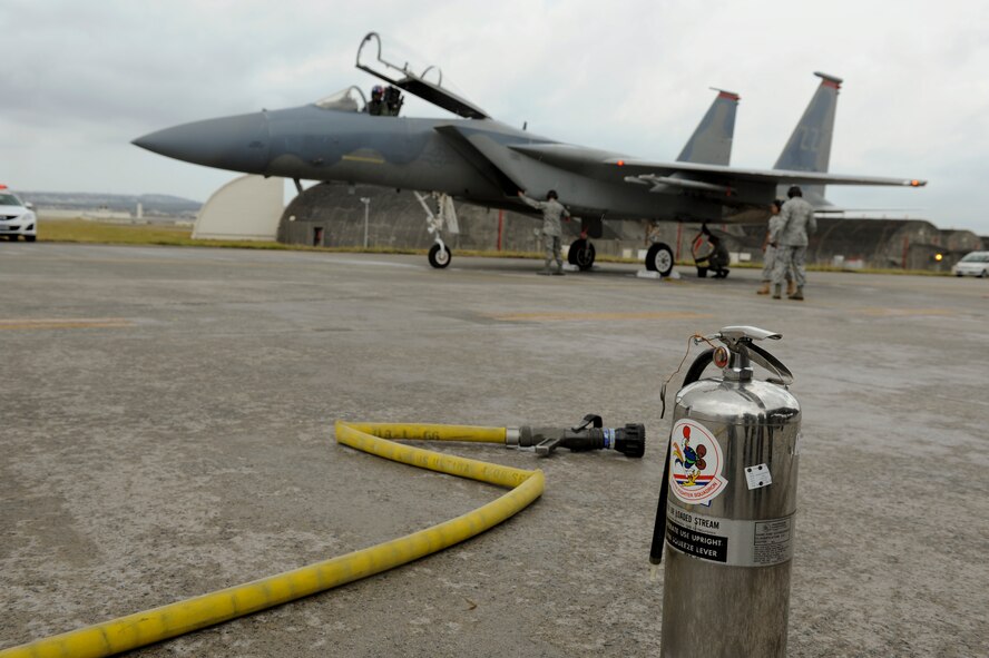 A fire house and extinguisher awaits Brig. Gen. Ken Wilsbach, 18th Wing Commander's arrival, as he taxis down Kadena’s runway after his “fini-flight” in an F-15 Eagle, June 1. As a tradition, the General was hosed down in celebration of the flight. (U.S. Air Force photo/Airman 1st Class Brooke P. Beers)
