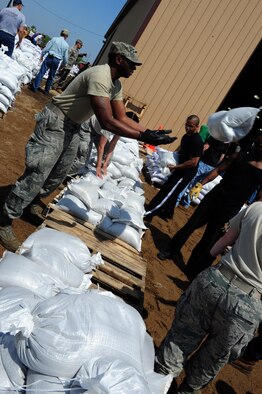 MINOT, N.D.-- Members of Team Minot work together to prepare sandbags for the incoming floods here June 1.  In preparation for possible flooding, the city of Minot, with assistance from Airmen from Minot Air Force Base, North Dakota National Guard as well as many other organizations, are setting up secondary dikes along the river. The Souris River threatens to break the levies already in place, thousands of Minot citizens, including military members, their families and DoD civilians, have been forced to evacuate the area.  (U.S. Air Force photo/Senior Airman Michael J. Veloz)