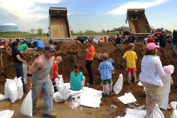 MINOT, N.D.-- Members of Team Minot work together to prepare sandbags for the incoming floods here June 1.  In preparation for possible flooding, the city of Minot, with assistance from Airmen from Minot Air Force Base, North Dakota National Guard as well as many other organizations, are setting up secondary dikes along the river. The Souris River threatens to break the levies already in place, thousands of Minot citizens, including military members, their families and DoD civilians, have been forced to evacuate the area.  (U.S. Air Force photo/Airman 1st Class Aaron-Forrest Wainwright)