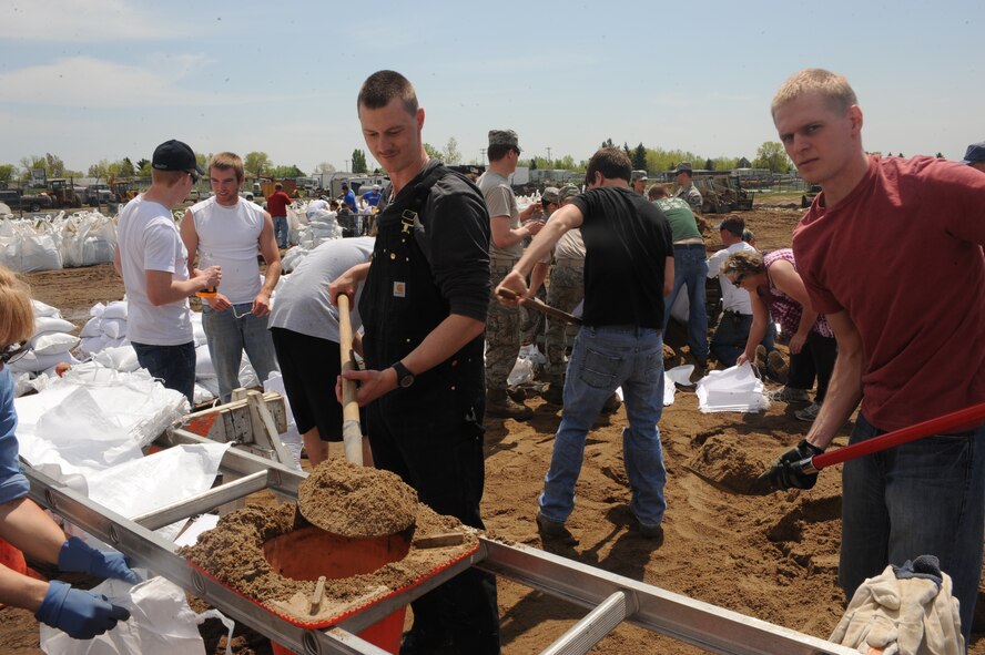 MINOT, N.D.-- Members of Team Minot work together to prepare sandbags for the incoming floods here June 1.  In preparation for possible flooding, the city of Minot, with assistance from Airmen from Minot Air Force Base, North Dakota National Guard as well as many other organizations, are setting up secondary dikes along the river. The Souris River threatens to break the levies already in place, thousands of Minot citizens, including military members, their families and DoD civilians, have been forced to evacuate the area.  (U.S. Air Force photo/Airman 1st Class Aaron-Forrest Wainwright)