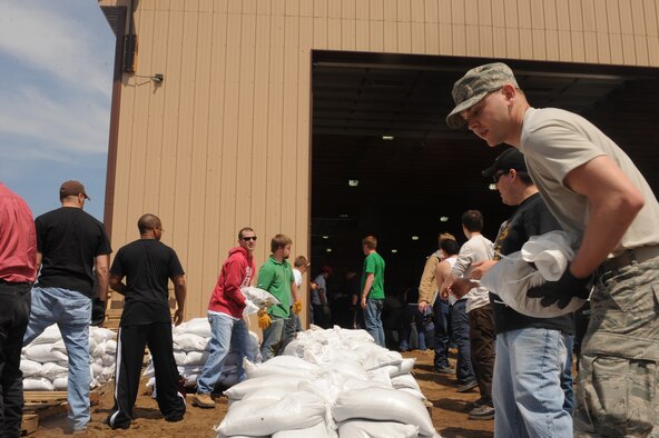 MINOT, N.D.-- Members of Team Minot work together to prepare sandbags for the incoming floods here June 1.  In preparation for possible flooding, the city of Minot, with assistance from Airmen from Minot Air Force Base, North Dakota National Guard as well as many other organizations, are setting up secondary dikes along the river. The Souris River threatens to break the levies already in place, thousands of Minot citizens, including military members, their families and DoD civilians, have been forced to evacuate the area.  (U.S. Air Force photo/Airman 1st Class Aaron-Forrest Wainwright)