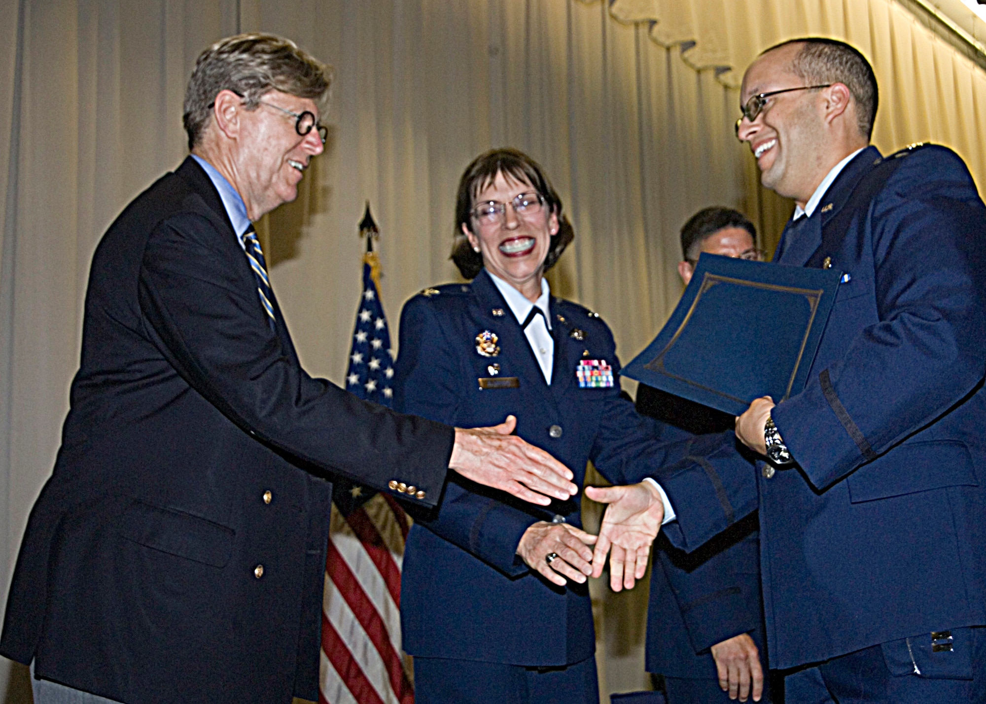 Dr. Albert Painter and Col. Kimberly Slawinski congratulate Capt. Matthew G. Adkins, during the graduation ceremony for Wright-Patterson Medical Center medical and dental education residents held May 26, 2011 at the National Museum of the U.S. Air Force.  Captain Adkins, an emergency medicine physician assistant, will be assigned to Eglin Air Force Base, Fla. Dr. Painter is assistant dean for Faculty Affairs, Wright State University Boonshoft School of Medicine and Colonel Slawinski is commander, 88th Medical Group at Wright-Patterson Air Force Base, Ohio. (U.S. Air Force photo/Mark Pugel) 