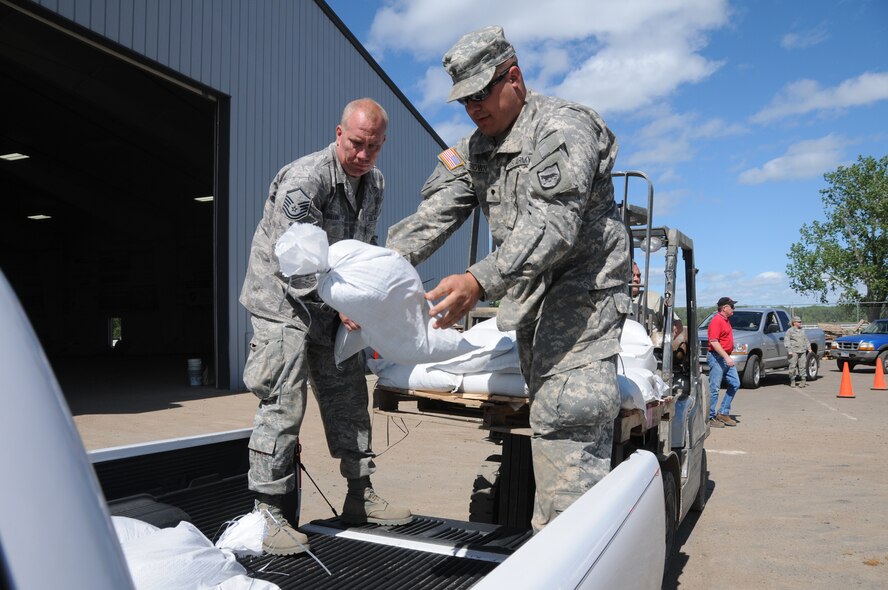 FT. PIERRE, S.D. -- Master Sgt. Darin Gillen from the 114th Fighter Wing Maintenance Squadron and Specialist Kurtis Brown, 235th Military Police from the Army National Guard load sandbags into a Ft. Pierre Resident's vehicle. Soldiers and Airmen from the South Dakota National Guard have been activated for state duty in preparation for flooding along the Missouri River throughout the state. (SDNG photo by Capt. Michael Frye) (RELEASED)
