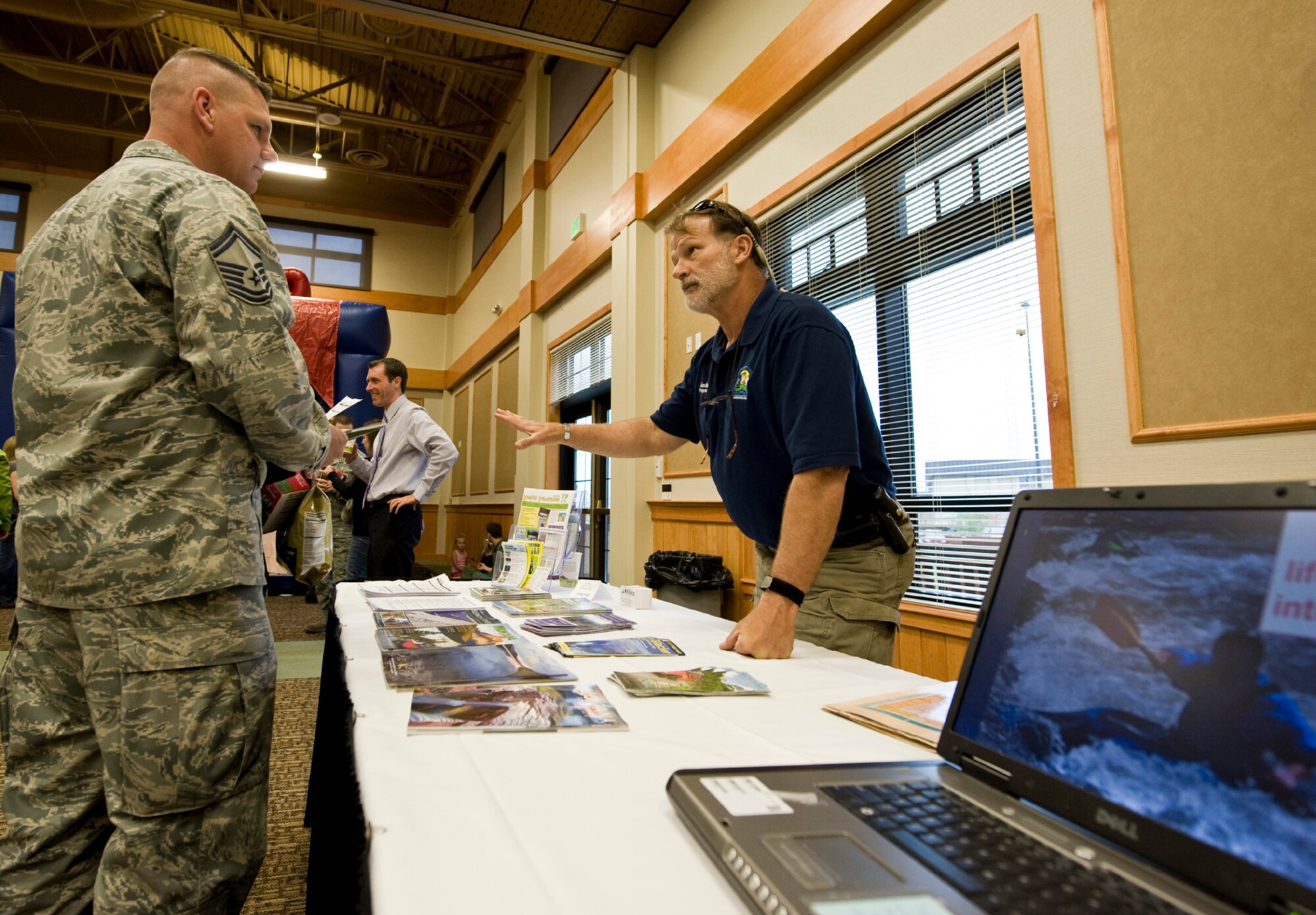 James Beisel, 341st Force Support Squadron programmer, right, describes some of the activities that the Outdoor Recreation office has planned.  Several vendors and agencies had tables set up in the main ballroom to demonstrate their services. (U.S. Air Force photo/John Turner)