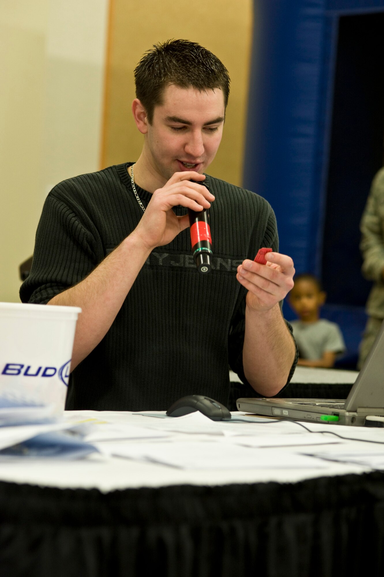 James Furst, from Mad Dog Karaoke, calls out the numbers on a winning ticket as door prizes are given away.  The prizes included rodeo tickets, day trips, gift cards and cash. (U.S. Air Force photo/John Turner)