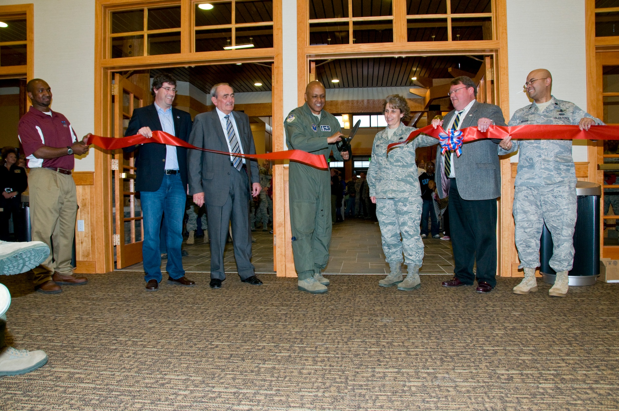 Brig. Gen. (Sel) Anthony Cotton, 341st Missile Wing commander, center, cuts a ceremonial ribbon inside the new Grizzly Bend Community Activities Center to mark the official opening of the facility.  Assisting him (from left to right) are:  David Weissman, Malmstrom civic leader for Air Force Global Strike Command; Warren Wenz, Malmstrom civic leader for the Chief of Staff of the Air Force; Chief Master Sgt. Cari Kent, 341st MW command chief; Steve Grooms, Military Affairs Committee chairman; and Lt. Col.  Billy Wade, 341st Force Support Squadron commander.  (U.S. Air Force photo/John Turner)
