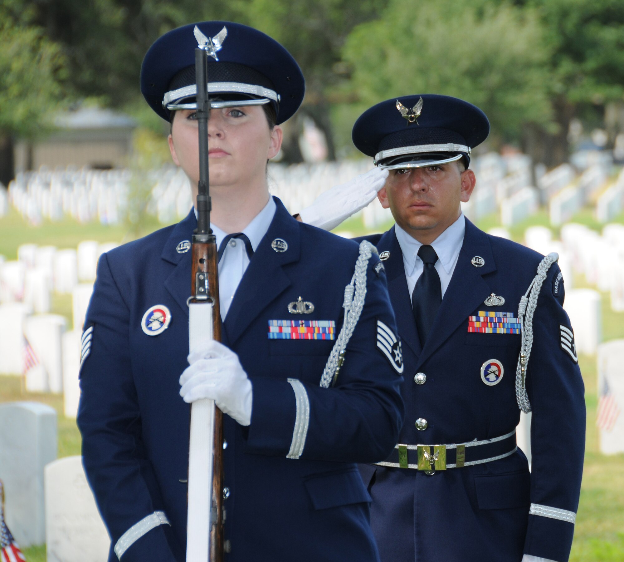 Staff Sgts. Rachel McDaniel, left, 334th Training Squadron, and Joe Rodriguez, 338th TRS, members of the Keesler Honor Guard, stand at attention while Taps is played during Monday’s Memorial Day ceremony at Biloxi National Cemetery. Brig. Gen. Andrew Mueller, 81st TrainingWing commander, was the guest speaker. Col. Glen Downing, 81st TRW vice commander, spoke at the holiday observance at Hattiesburg Memorial Park and Airman Leadership School staff and members of Class 11-4 conducted a POW/MIA table ceremony at the Armed Forces Retirement Home in Gulfport.  (U.S. Air Force photo by Kemberly Groue)