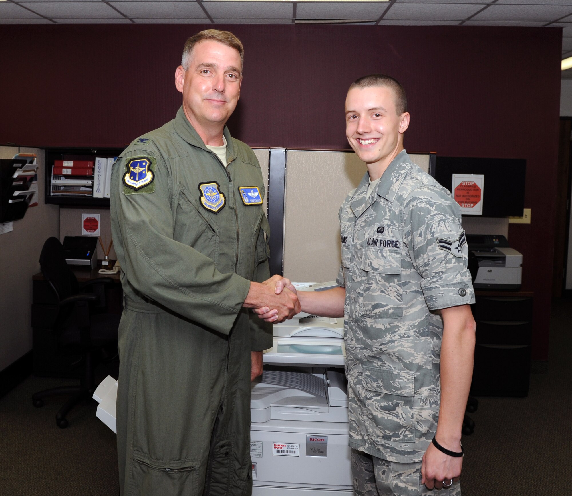 Col. Mike Minihan, 19th Airlift Wing commander, presents his commander’s coin May 31, 2011, to Airman 1st Class Alex Collins, a 19th Comptroller Squadron lead counter technician, for his selection as the Combat Airlifter of the Week. Airman Collins processed more than 350 Defense Travel System orders for redeployers within 24 hours, ensuring Little Rock Airmen were mission-ready. His work contributed to the flight winning the 2010 Air Mobility Command Financial Services Office of the Year. (U.S. Air Force photo/Airman 1st Class Rusty Frank)