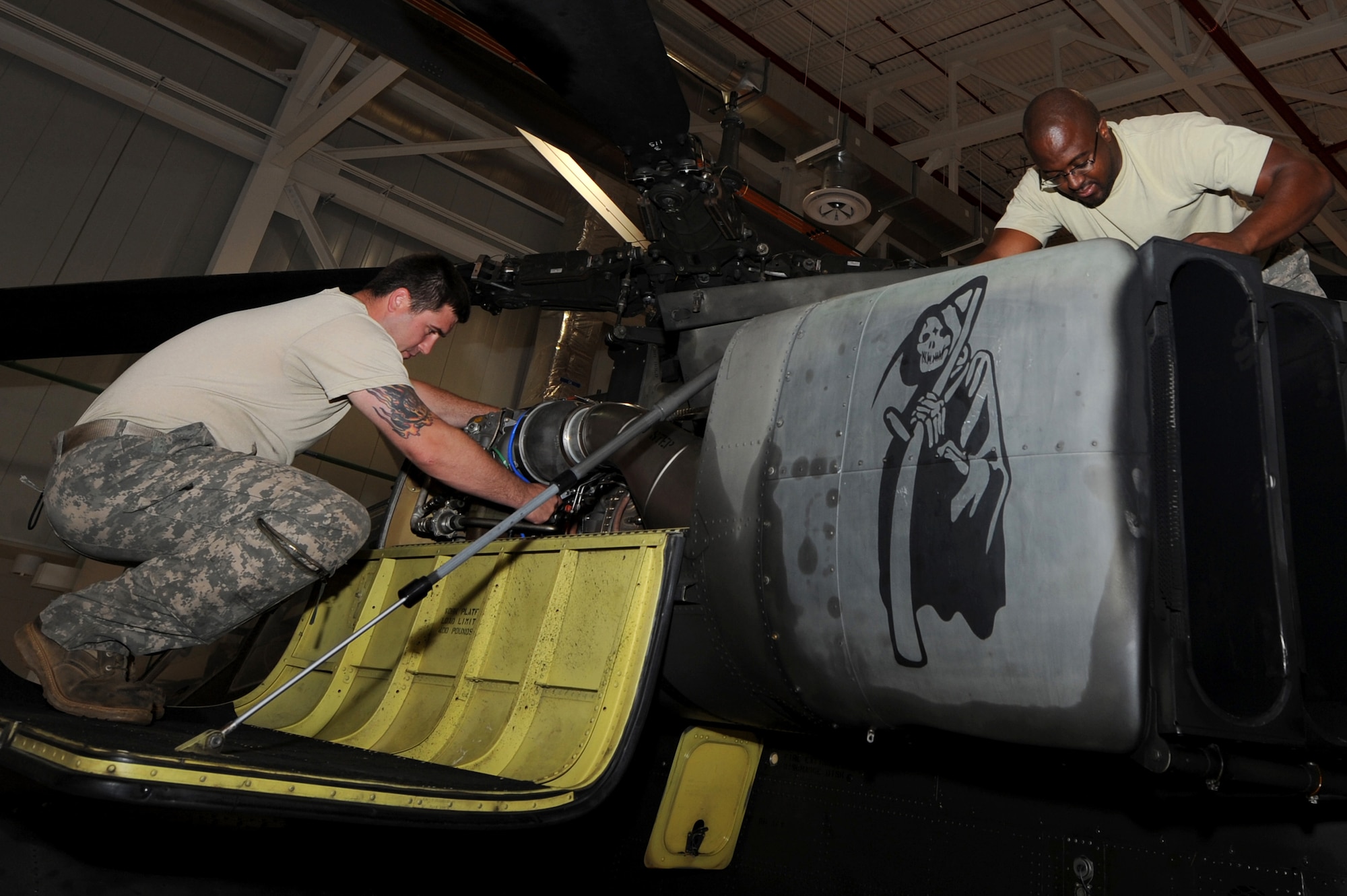 WHITEMAN AIR FORCE BASE, Mo. -- Staff Sgt. Ryan Cody and Sgt. 1st Class Andrew Butler, aircraft maintainers from the 1-135th Attack Reconnaissance Battalion, inspect the engine of a Boeing AH-64 Apache helicopter May 31. The AH-64 features a nose-mounted sensor suite for target acquisition and night vision systems. (U.S. Air Force photo by Senior Airman Alexandra M. Boutte) (RELEASED)