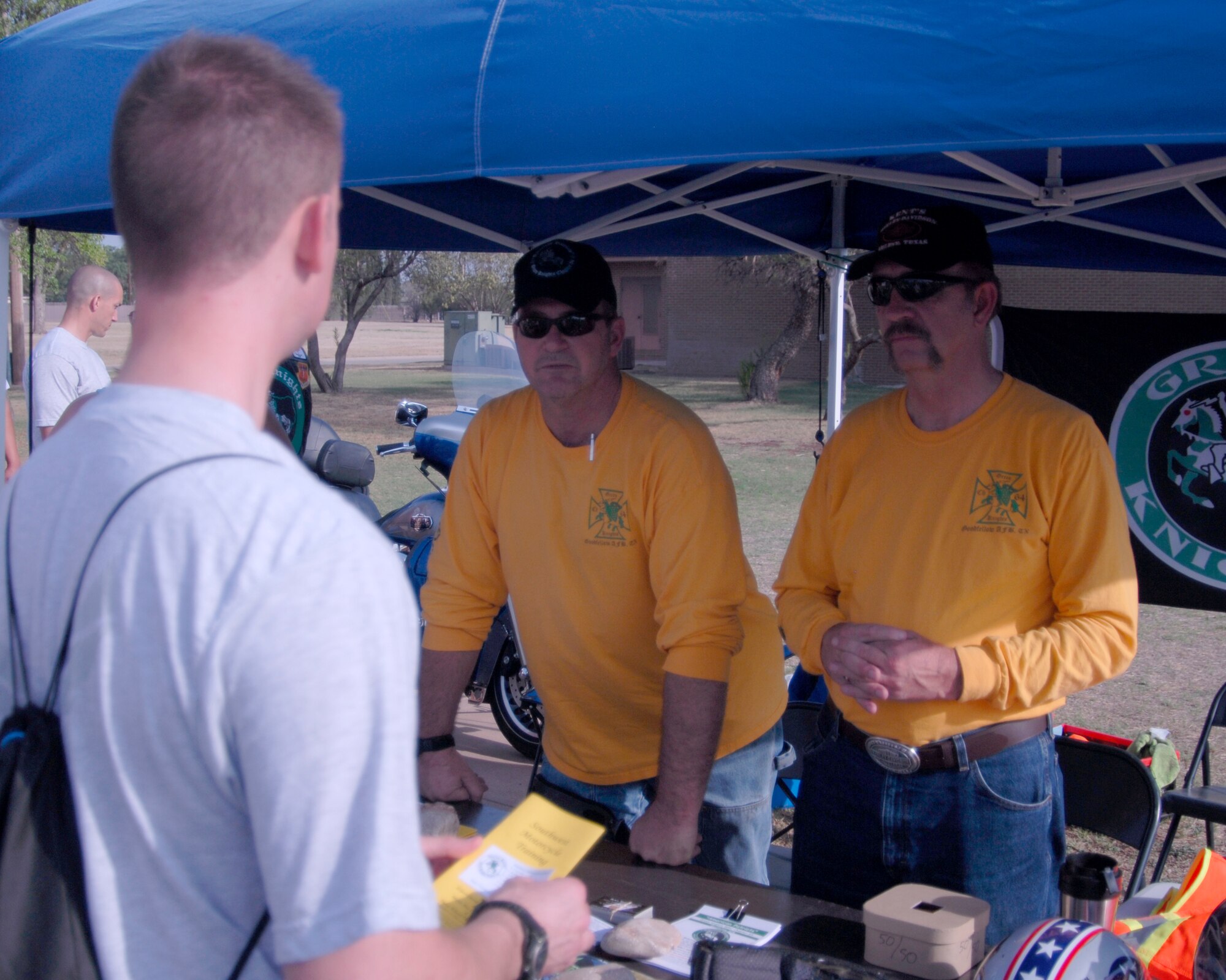 GOODFELLOW AIR FORCE BASE, Texas - Roy Powell (center) and Ken Roxburgh (right) with the Green Knights Military Motorcycle Club, Chapter 64, speak with an Airman about motorcycle safety during Safety Day activities May 27. The Green Knights promote and educate the on- and off-base communities on safe riding practices. (U.S. Air Force photo/Tech. Sgt. Jon DuMond)

