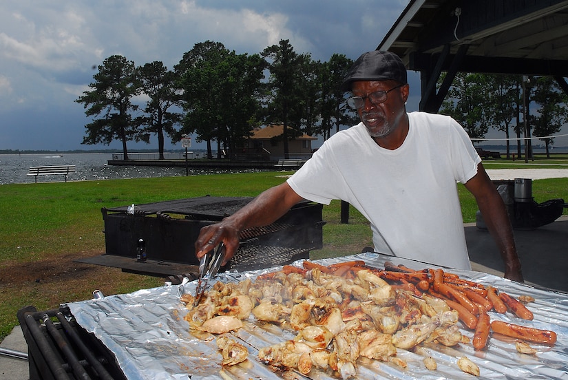 Julius Middleton, from Hollyhill, S.C., grills chicken and hotdogs for a family gathering during the Memorial Day weekend at Short Stay Navy Outdoor Recreation area on Lake Moultrie near Moncks Corner, S.C., May 28. Mr. Middleton was spending time with his family and son, Yeoman Chief Petty Officer Travar Middleton who is stationed at the Office of Chief of Navy Reserve in Washington, D.C., and was visiting during the holiday weekend.  (U.S. Navy photo/Machinist's Mate 3rd Class Brannon Deugan)
