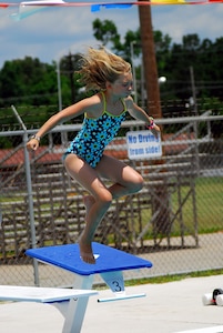 Ten year-old Angel Bolt, daughter of Machinist's Mate 1st Class Todd Bolt stationed at Nuclear Power Training Unit, jumps off the diving board at Joint Base Charleston-Weapons Station’s New Wave Aquatic Center, May 29.  The base pools on the Weapons Station and the Air Base opened for Memorial Day weekend and will provide active duty service members, retired military, reservists, DoD personnel and DoD contractors a chance to enjoy the water and the sunshine all summer long.  (U.S. Navy photo/ Machinist’s Mate 3rd Class Brannon Deugan)
