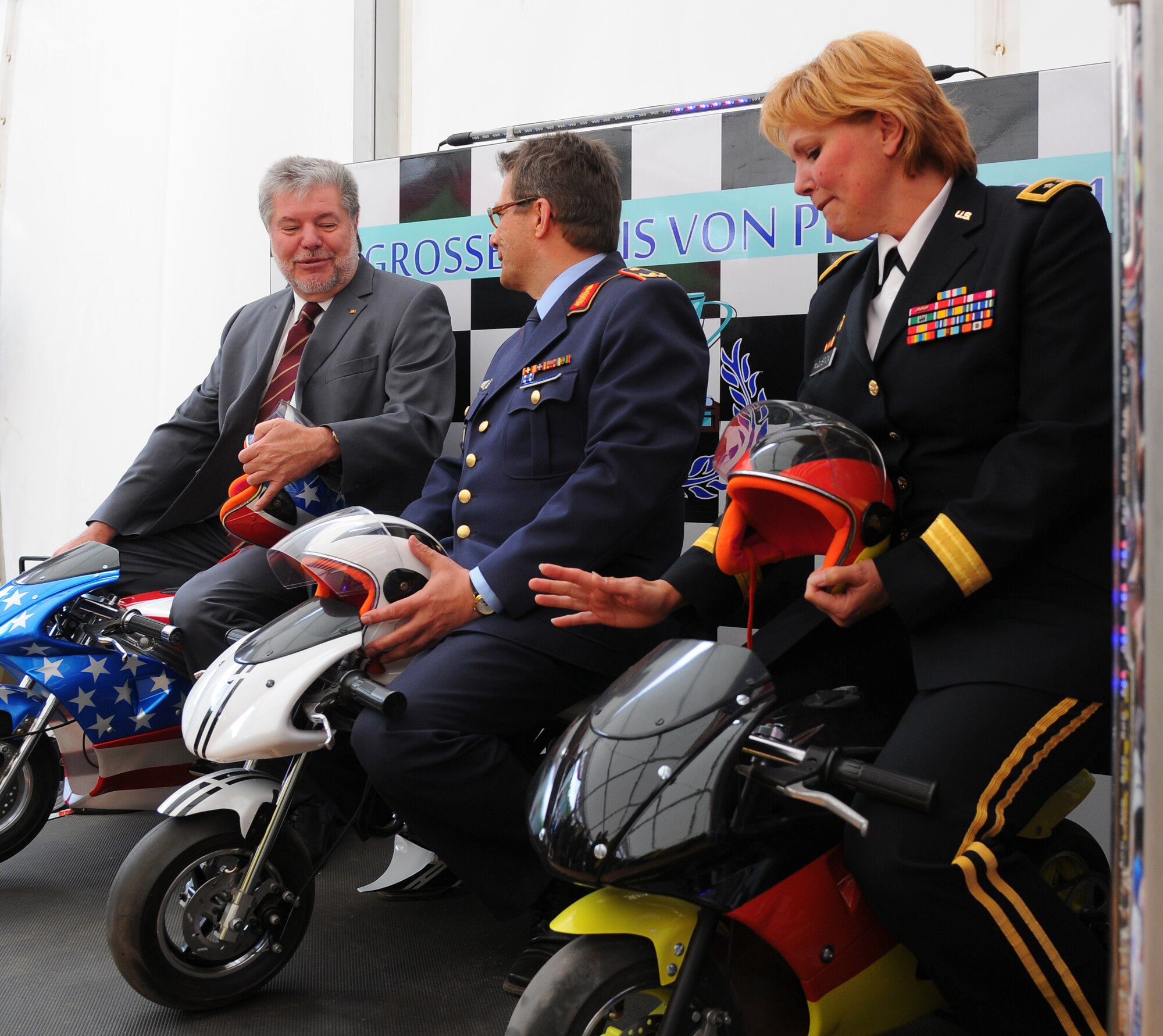 PRUEM, Germany – Kurt Beck, Rheinland-Pfalz minister president, poses for photos on miniature motorcycles with German and U.S. military officers during the Rheinland-Pfalz Day Fair in Pruem, Germany, May 28. The Rheinland-Pfalz Day Fair is a three-day festival with entertainment, informational booths and other attractions. (U.S. Air Force photo/Airman 1st Class Dillon Davis)