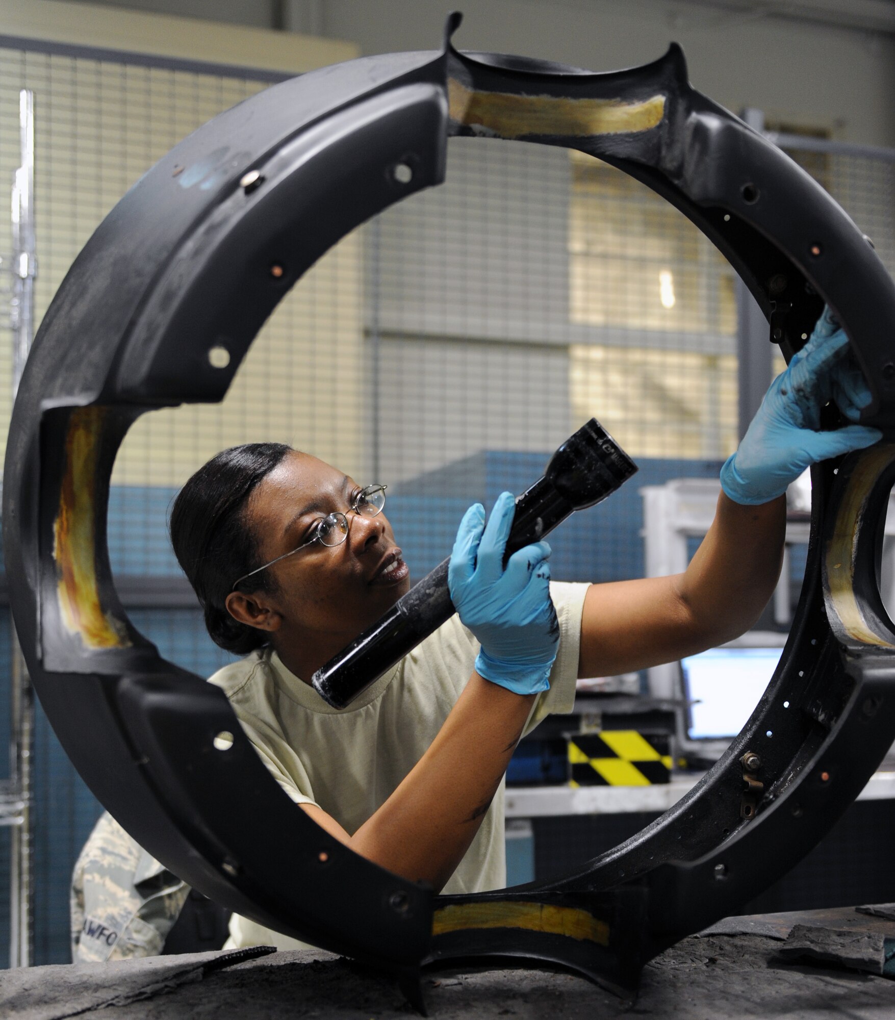 Staff Sgt. Alecia Crawford, a 19th Component Maintenance Squadron aerospace propulsion journeyman, inspects a rear spinner for cracks May 31, 2011, at Little Rock Air Force Base, Ark. Inspecting the rear spinner is part of the disassembly and re-assembly process of a C-130 propeller. (U.S. Air Force photo by Airman 1st Class Rusty Frank) 