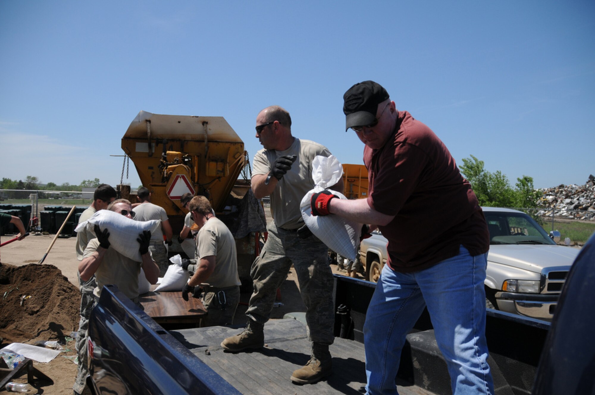 PIERRE, S.D. -- Tech. Sgt. Kevin Elder, a Crew Chief with the 114th Fighter Wing, assists Pierre resident Mark Barnett with another load of sandbags. More than 200 South Dakota Air National Guard Airmen were activated on May 30 as part of an effort to minimize flooding throughout the cities of Pierre and Ft. Pierre, S.D. More than 100 additional Airmen were activated on May 31 to Dakota Dunes, S.D., to assist with flood relief in that area of the state.(SDNG photo by Capt. Michael Frye, 114th Fighter Wing Public Affairs Officer) (RELEASED)
