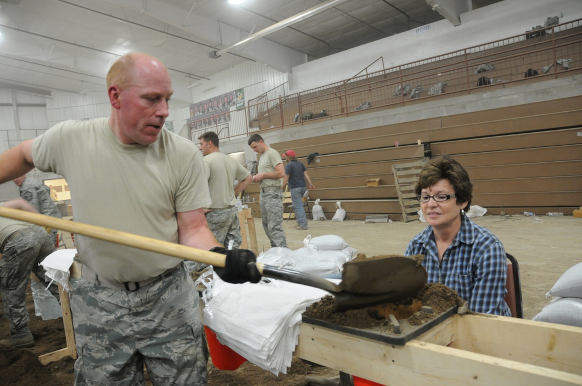 FT. PIERRE, S.D. -- Capt. Kevin Miller, Budget Officer for the 114th Financial Management Flight, works with Donna Brown-Glow, a Wood, S.D. and Ft. Pierre resident to fill sandbags late into the evening on May 31. Brown-Glow's home has not been threatened by the flooding, but feels it's important to help others throughout the state.(Photo by Capt. Michael Frye, 114th Fighter Wing Public Affairs Officer) (RELEASED)
