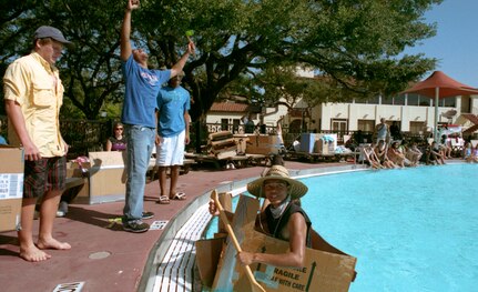 During the Fourth Annual Randolph High School Physics and PreCal Cardboard Boat Regatta, (on deck left to right):  Will Perrin and OJ Jackson look on while Jordan Young exclaims with his hands at the progress of sailor Jimmy Sherrod.
(U,S, Air Force photo/Brian McGloin)