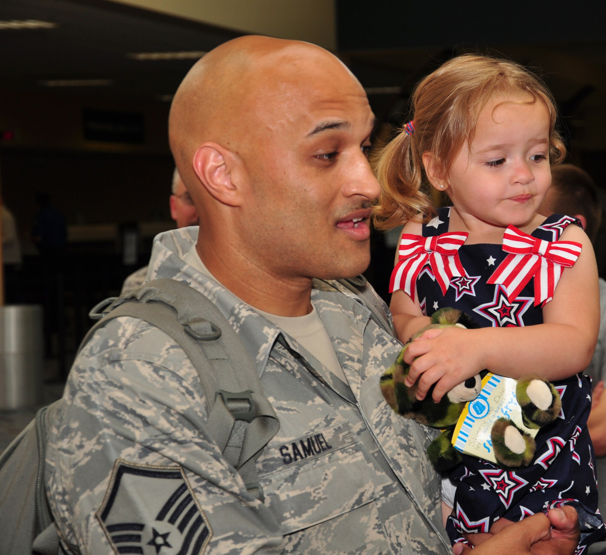 WRIGHT-PATTERSON AIR FORCE BASE, Ohio – Master Sgt. Cleve Samuel , 87th Aerial Port Squadron, holds his daughter, Chloe, at the Dayton International Airport May 24 after returning from a  4-month deployment to Southwest Asia.  (U.S. Air Force photo/Senior Airman Mikhail Berlin)
