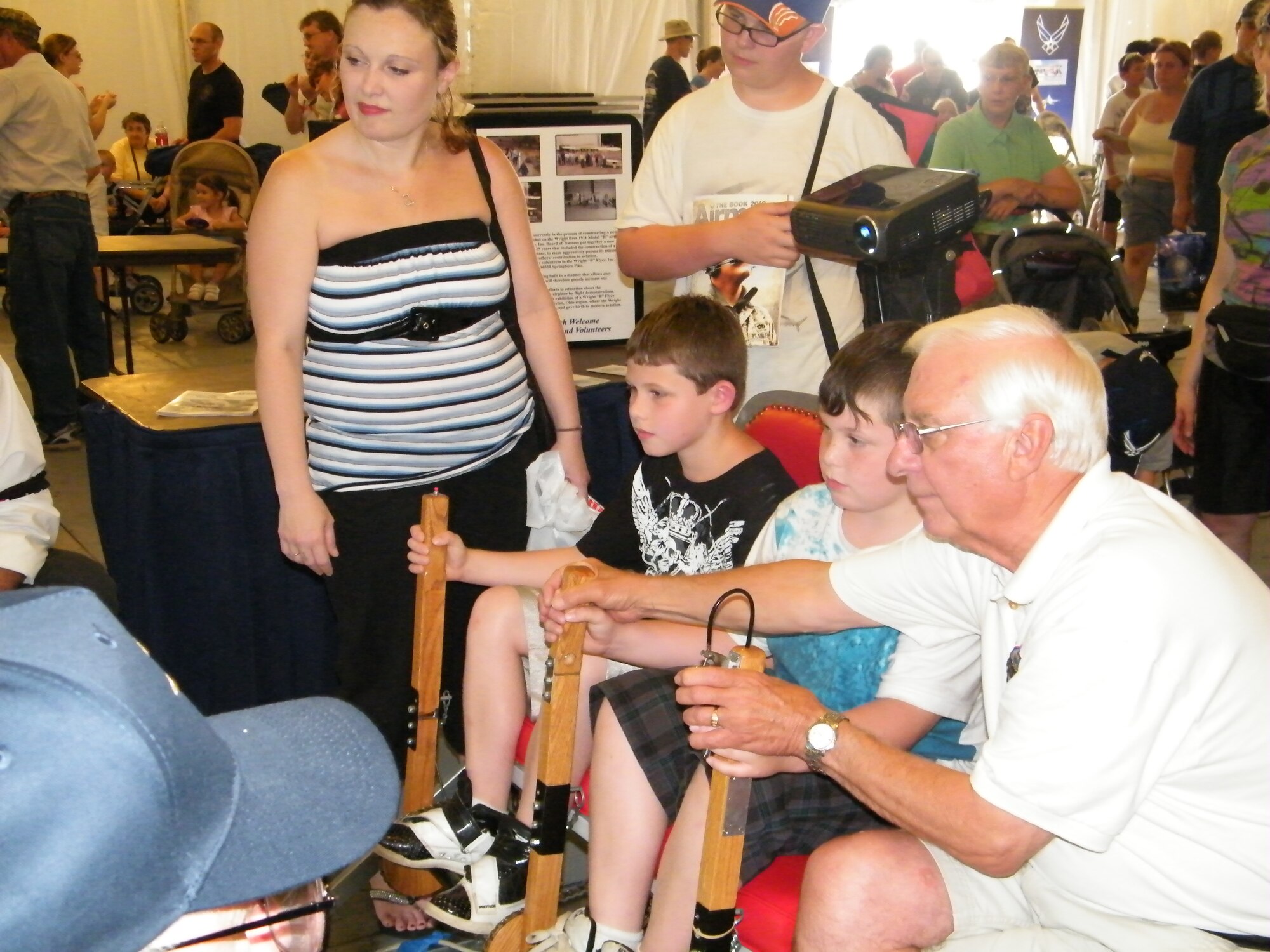 A small crowd gathers as Tattoo attendees check out a flight simulator in the Technology Exposition Tent.  The Technology Tent is one of the highlights of Freedom’s Call Tattoo, which will be held June 24 this year.   (U.S. Air Force photo/ Jim Palmer)