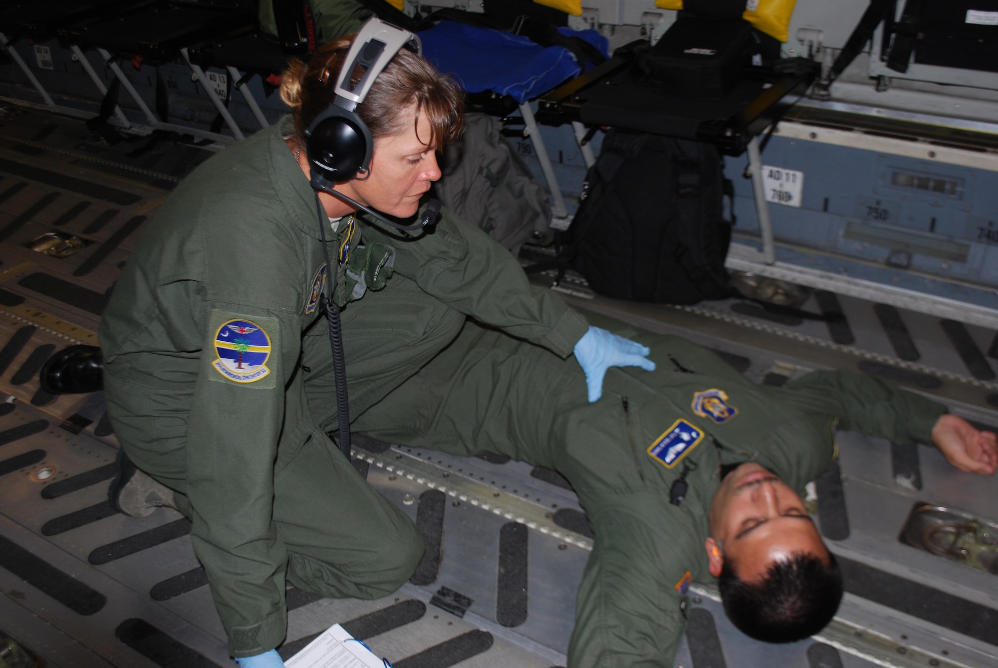 Staff Sergeant Brigid Dye (left) and Technical Sergeant Deaun Davis demonstrate an aeromedical evacuation on a C-17.  Both SSgt Dye and TSgt Davis are apart of the 315th Aeromedical Evacuation Squadron (AES). (U.S. Air Force photo taken by Lt. Col. Bill Walsh)