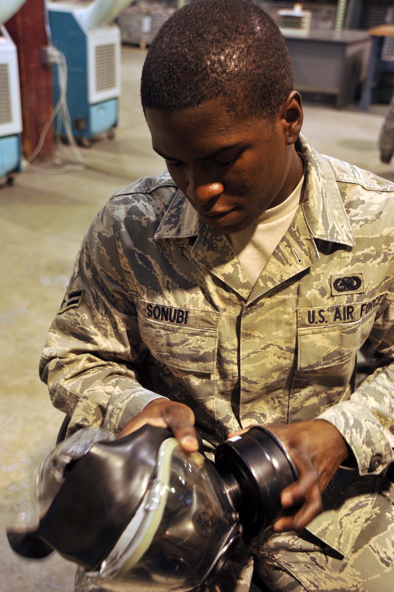 Airman 1st Class Olukayode Sonubi, 22nd Logistics Readiness Squadron Individual Protective Equipment apprentice, inspects a gas mask filter before issuing it to a McConnell Airman June 1, 2011, McConnell Air Force Base, Kan.  The Temple, Ga., native assists more than 50 McConnell members a week with deployments and redeployments, while also keeping an inventory and accountability of all equipment in the IPE warehouse.  (U.S. Air Force photo/Senior Airman Abigail Klein)