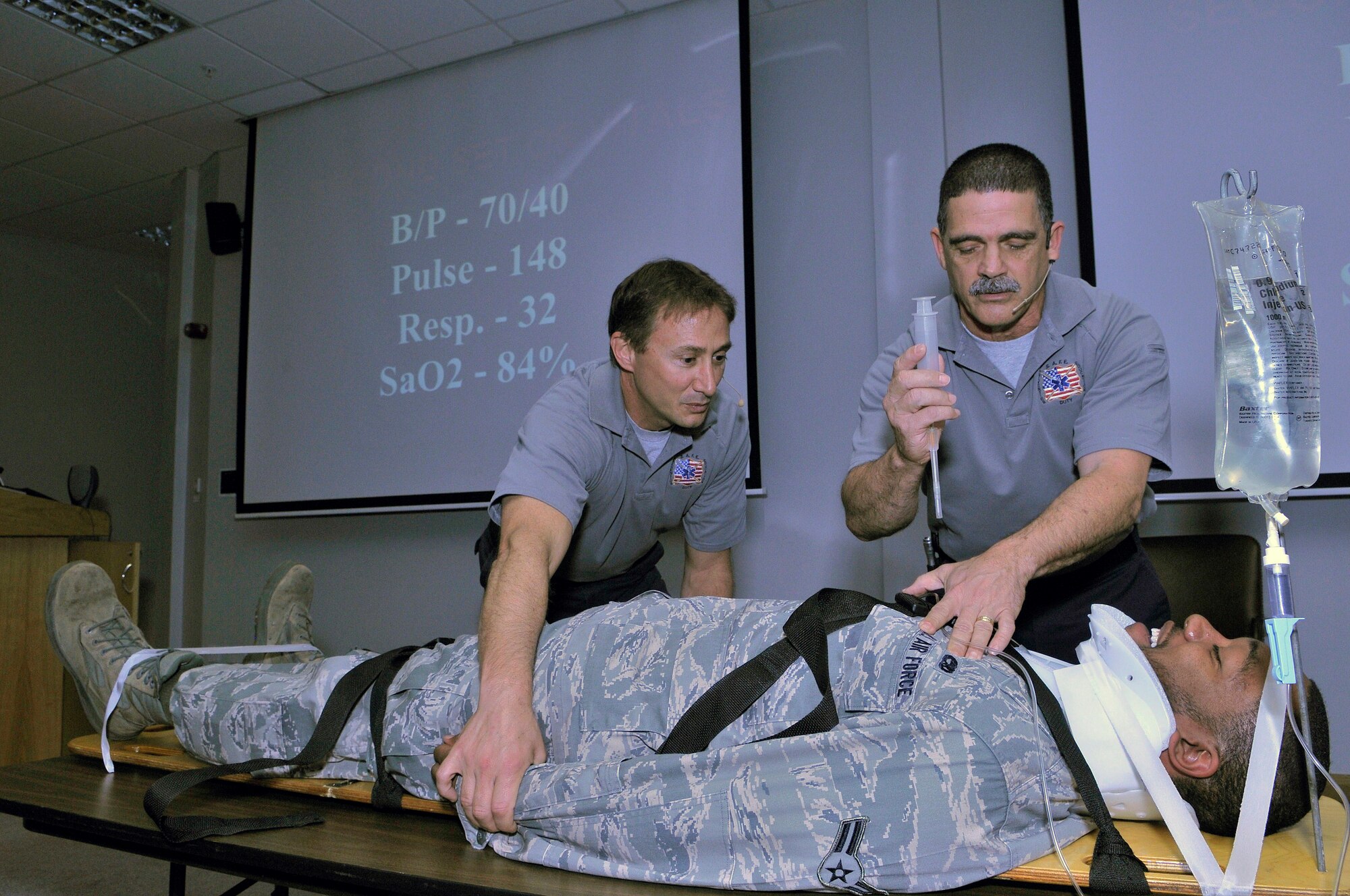 ROYAL AIR FORCE LAKENHEATH, England -- Mr. Vince Easevoli (left) and Mr. Ronny Garcia, firefighter paramedics from Florida, simulate emergency life-saving procedures on Airman 1st Class Ronya Sturdivant, 48th Muntions Squadron armament systems maintainer, during the Operation Street Smart briefing May 31, 2011. The Stay Alive From Education, Operation Street Smart program educates people on the consequences of poor decision-making and focuses on making drivers aware of the dangers of driving under the influence of alcohol or drugs, not wearing seatbelts and the trauma associated with a serious accident.  (U.S. Air Force photo/Staff Sgt. Connor Estes