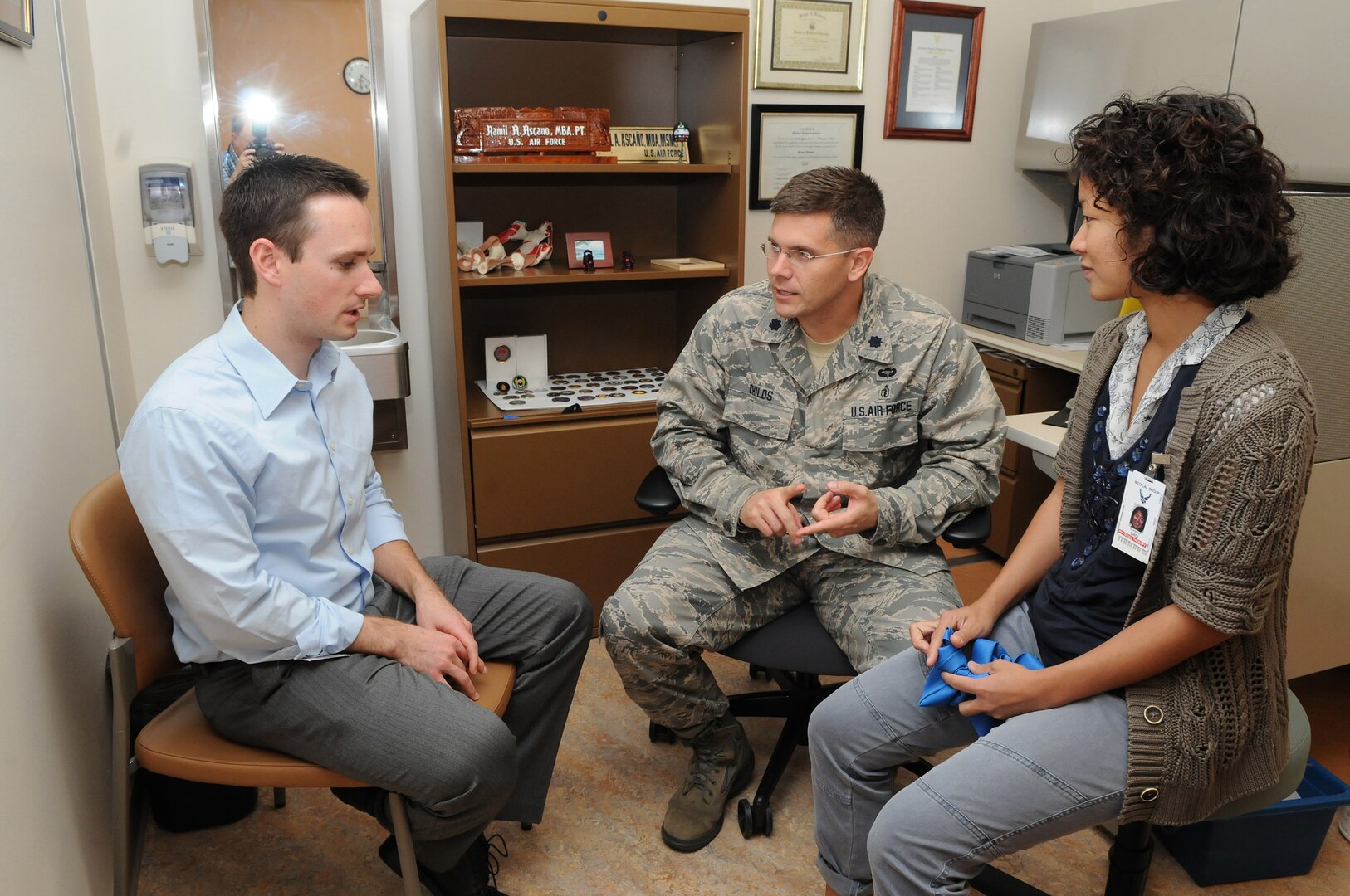 Air Force Lt. Col. John Childs, center, Principal  Investigator on a study of knee osteoarthritis, meets with physical therapists Brett Neilson  and Harmony Choi, at the Physical Therapy Clinic at Randolph Air Force Base, Texas.  The physical therapists are participating in the study of knee osteoarthritis. (U.S. Air Force photo/David Terry)