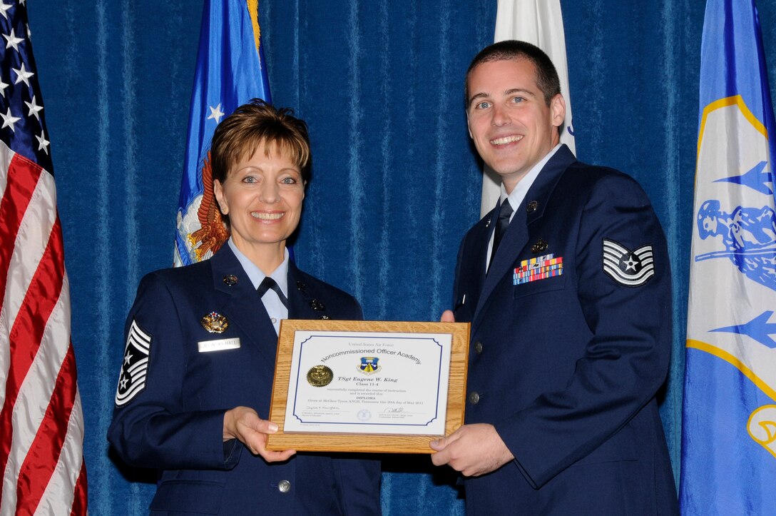 McGHEE TYSON AIR NATIONAL GUARD BASE, Tenn. - Air Force Tech. Sgt. Eugene W. King, right, receives the distinguished graduate award for NCO Academy Class 11-4 at The I.G. Brown Air National Guard Training and Education Center here from Chief Master Sgt. Denise Jelinski-Hall, May 20, 2011.  The distinguished graduate award is presented to students in the top ten percent of the class.  It is based on objective and performance evaluations, demonstrated leadership, and performance as a team player. (U.S. Air Force photo by Master Sgt. Kurt Skoglund/Released)