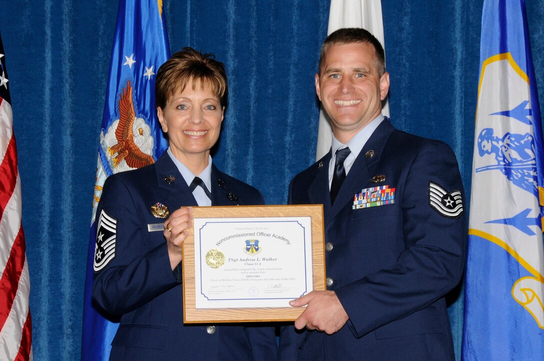 McGHEE TYSON AIR NATIONAL GUARD BASE, Tenn. - Air National Guard Tech. Sgt. Andrew L. Walker, right, receives the distinguished graduate award for NCO Academy Class 11-4 at The I.G. Brown Air National Guard Training and Education Center here from Chief Master Sgt. Denise Jelinski-Hall, May 20, 2011.  The distinguished graduate award is presented to students in the top ten percent of the class.  It is based on objective and performance evaluations, demonstrated leadership, and performance as a team player. (U.S. Air Force photo by Master Sgt. Kurt Skoglund/Released)