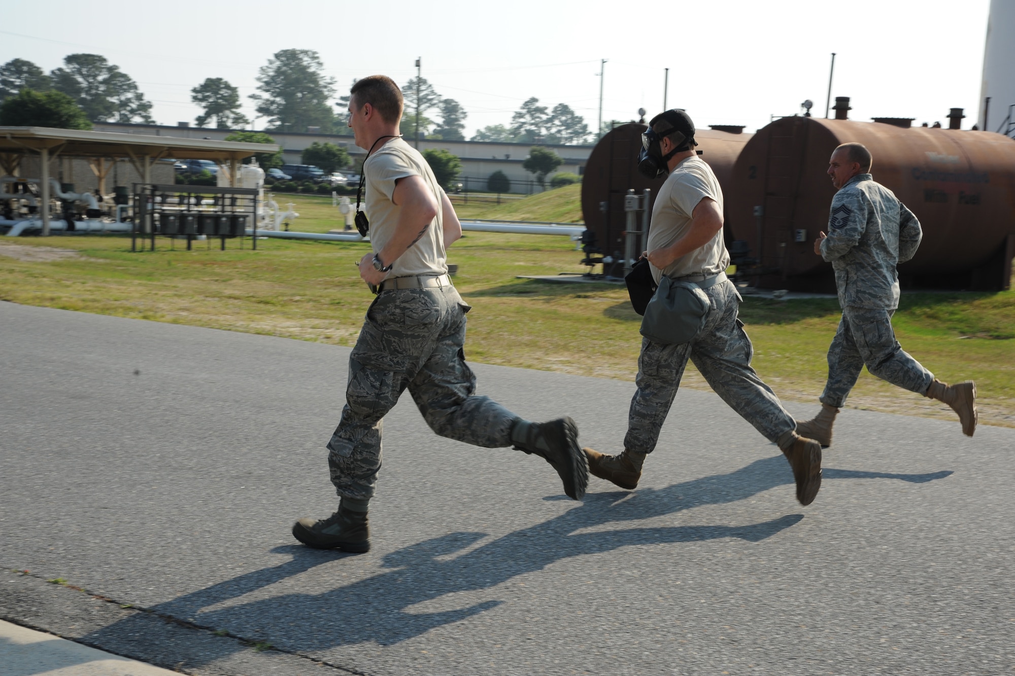 SEYMOUR JOHNSON AIR FORCE BASE, N.C.- Chief Master Sgt. Dean Abbott paces Staff Sgts. Jeremy Varney and David Smith as they respond to a refuel request during the fuels operator challenge as part of the Wing Turkey Shoot here, May 25, 2011. The operator challenge was a timed event requiring teams to demonstrate their ability to identify refueling unit discrepancies and maneuver an R-11 refueler truck through an obstacle course while the vehicle operator wore a gas mask. Chief Abbott, 4th Logistic Readiness Squadron fuels manager, hails from Roanoke, Va.  Sergeant Varney, 4th LRS fuels distribution supervisor, is from Dudley. Sergeant Smith, 4th LRS fuels resource controller is from Sterling, Ill. (U.S. Air Force photo/Senior Airman Whitney Lambert)(RELEASED)