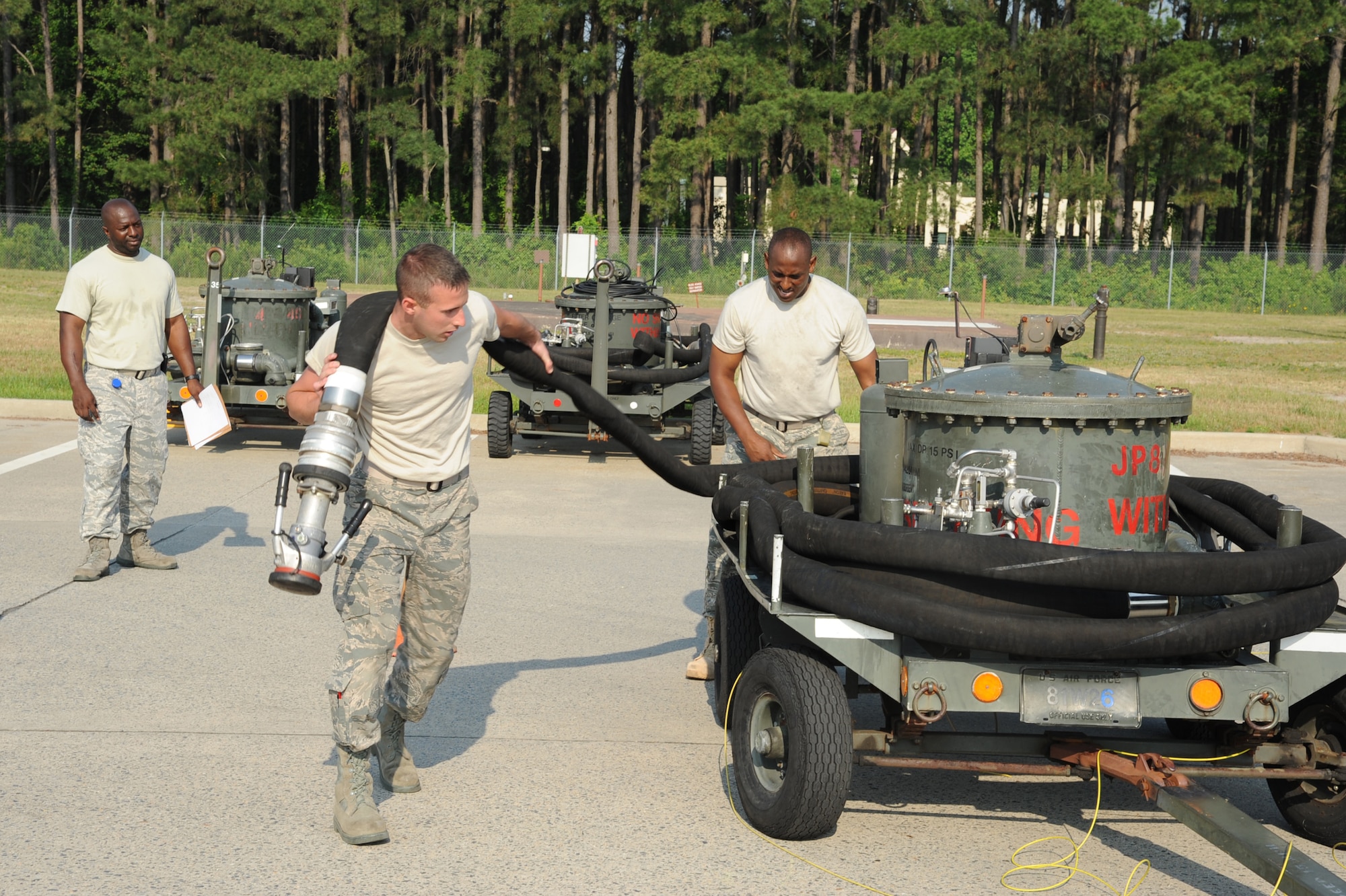SEYMOUR JOHNSON AIR FORCE BASE, N.C.- Master Sgt. Joseph Vaughn(left) evaluates Master Sgt. Robert Elliott and Airman 1st Class Kurtis Schiemann as they properly stow hoses on mobile hydrant equipment here, May 25, 2011. The event was part of the 4th Logistic Readiness Squadron fuels flight's Wing Turkey Shoot. Master Sgt. Vaughn is the 4th LRS fuels terminal operations NCOIC and hails from Demotolis, Ala. Master Sgt. Elliott is the 4th LRS fuels distribution NCOIC and is a native of Fayetteville.  Airman Schiemann 4th LRS fuels distribution operator is a native of Gladwin, Mich.  (U.S. Air Force photo/Senior Airman Whitney Lambert)(RELEASED)