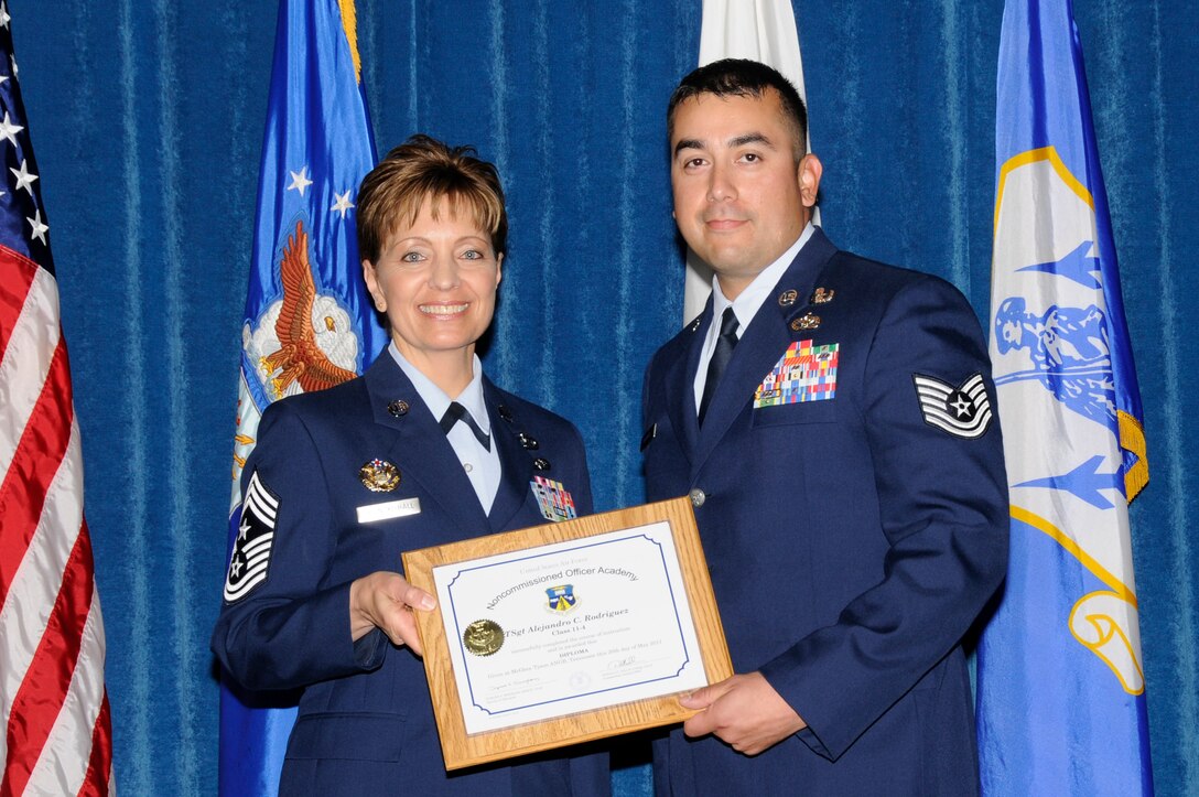 McGHEE TYSON AIR NATIONAL GUARD BASE, Tenn. - Air Force Tech. Sgt. Alejandro C. Rodriquez, right, receives the distinguished graduate award for NCO Academy Class 11-4 at The I.G. Brown Air National Guard Training and Education Center here from Chief Master Sgt. Denise Jelinski-Hall, May 20, 2011.  The distinguished graduate award is presented to students in the top ten percent of the class.  It is based on objective and performance evaluations, demonstrated leadership, and performance as a team player. (U.S. Air Force photo by Master Sgt. Kurt Skoglund/Released)