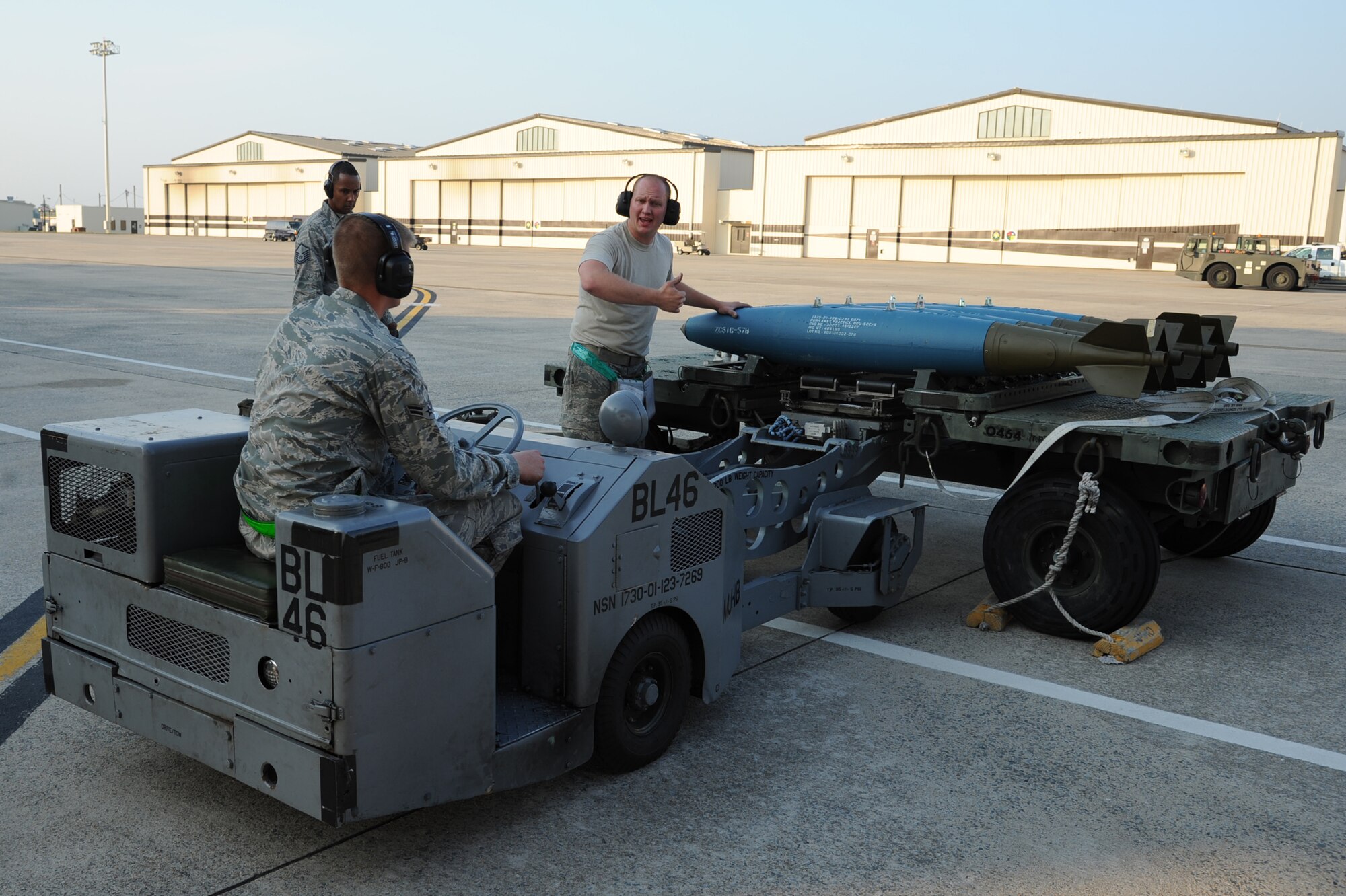 SEYMOUR JOHNSON AIR FORCE BASE, N.C.- Staff Sgt. Adam Cox directs Airman 1st Class Jeremy Huuki while driving a MJ-1 bomb lift truck as Master Sgt. David Frier evaluates them during a weapons load competition as a part of the Wing Turkey Shoot here, May 25, 2011. The evaluator ensures the Airmen do not miss any steps, which could result in them being de-certified on that munition and subtract points from their squadron. Airman Huuki hails from Tamarack City, Mich., and is a 4th Aircraft Maintenance Squadron weapons load crew member.  Sergeant Cox hails from Chesapeake, Va., and is a 4th AMXS weapons load crew chief. Master Sgt. Frier is an 4th AMXS lead standardization crew member and is a native of Wuharton, Texas. (U.S. Air Force photo/Senior Airman Whitney Lambert)(RELEASED)