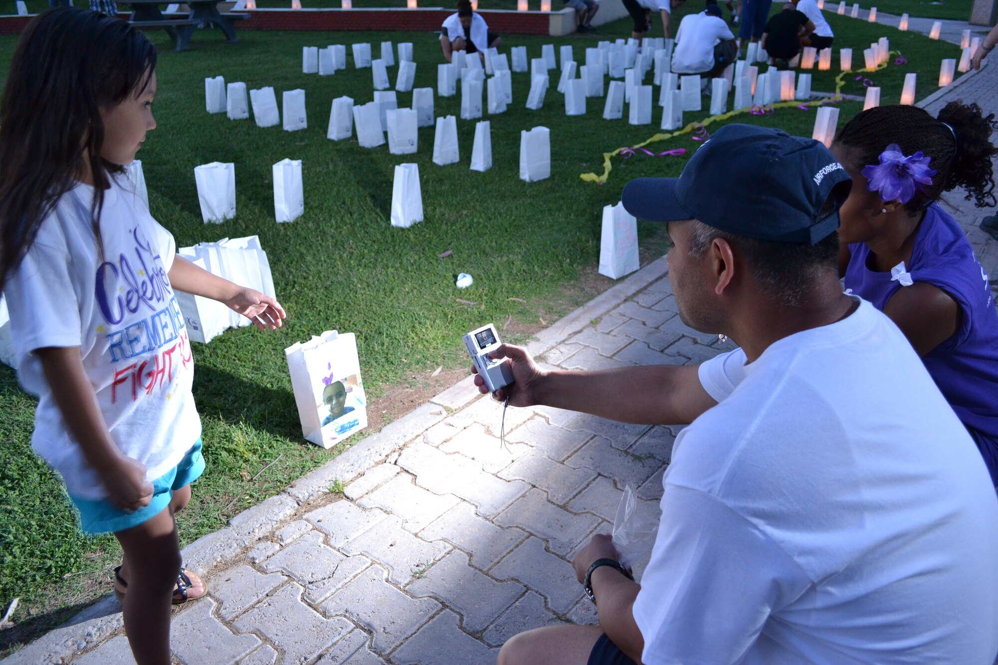 Members of the Incirlik Community take photos and video of the luminaries they created for survivors and victims of cancer during the Relay for Life event held at Arkadas Park May 21, 2011 at Incirlik Air Base, Turkey. Incirlik raised $21,824 in contributions this year. The relay helped raise money for cancer research and cancer patients. The event is held to spread cancer awareness, celebrate the lives of survivors and remember those who lost their lives to cancer. To end the event, families and friends decorated paper bags filled with sand and a candle to illuminate the bag. (U.S. Air Force photo by Staff Sgt. Alexandre Montes/ Released)