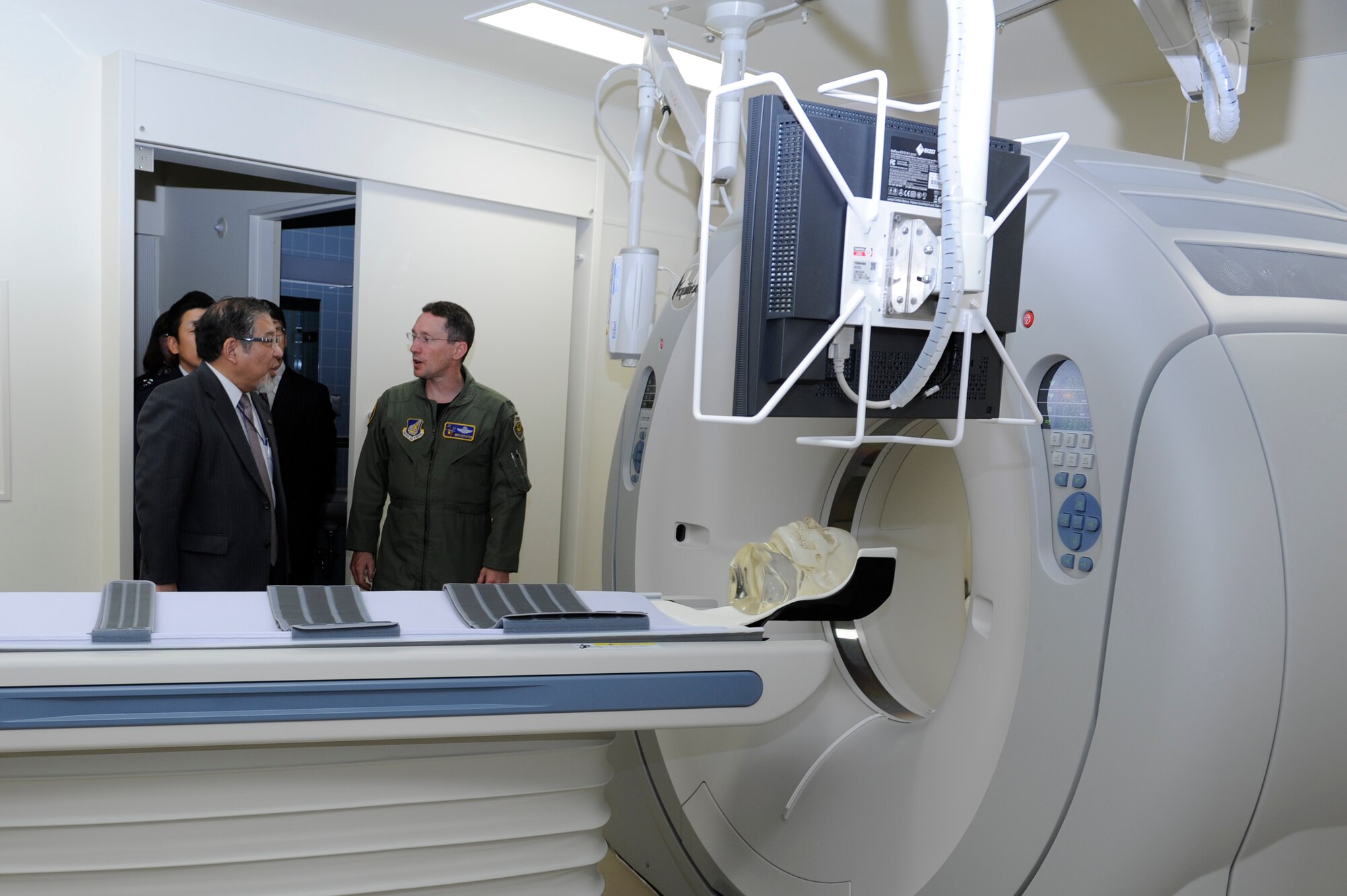 MISAWA AIR BASE, Japan -- Dr. Yuh Sakata, Misawa City Hospital chief executive officer, left, and Col. Michael Rothstein, 35th Fighter Wing commander, discuss the new CT scanner at the 35th Medical Group Diagnostic Imaging Department June 1. With this scanner, the 35th MDG will be able to perform 100 percent of its CT scans in-house, representing a major change in contingency operations as all prior patients needing CT scans were sent to Misawa City Hospital. (U.S. Air Force photo/Staff Sgt. 
Marie Brown/Released)