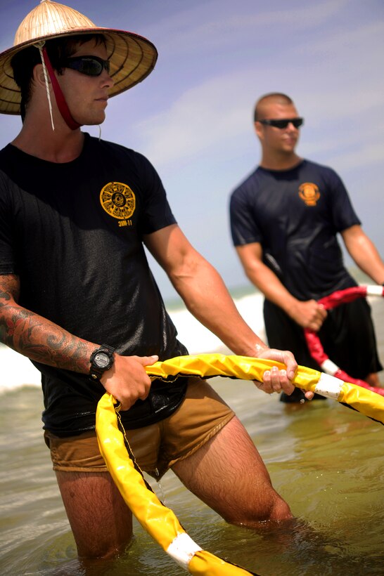 U.S. Navy Petty Officer 2nd Class James Maxey, left, and Petty Officer 1st Class Walter Dishongh, right, stand as dive tenders during a Joint POW/MIA Accounting Command recovery mission, Thua Thien Hue, Vietnam, May 21, 2011. Maxey and Dishongh are divers assigned to Mobile Diving and Salvage Unit 1, Joint POW/MIA Accounting Command.