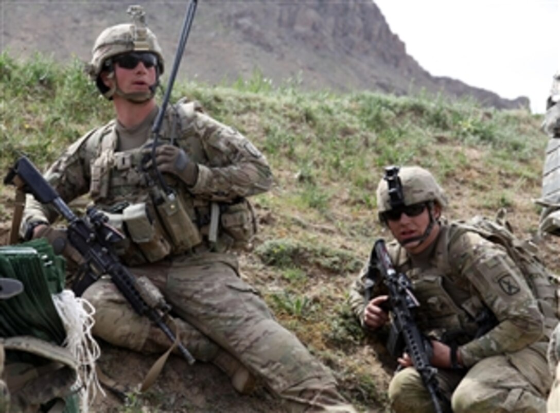U.S. Army 1st Lt. Theo Kleinsorge (left), with 1st Platoon, Delta Company, 2nd Battalion, 30th Infantry Regiment, and Spc. Kaleb Ivanoff take cover behind a hill while receiving enemy fire near the village of Mereget, in Kherwar district, Logar province, Afghanistan, on May 10, 2011.  