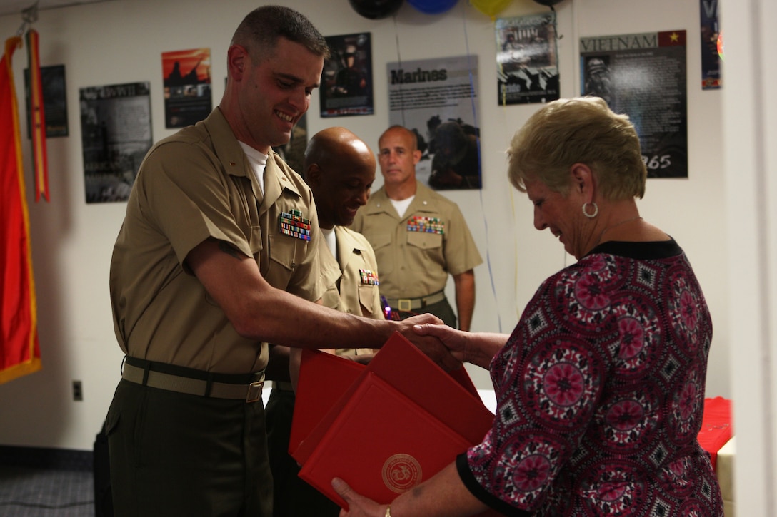 Virginia Court, deputy director of the Marine Corps Combat Service Support Schools Personnel Administration Center, receives various letters of appreciation as well as her certificate of retirement from Chief Warrant Officer 2 Michael McCarr, director of the MCCSSS PAC, during Court’s retirement at the Camp Johnson Bachelor Officers’ Quarters, June 3. Court retired after serving 40 years combined federal service for the Department of Defense, 35 of those years spent with the Marine Corps.