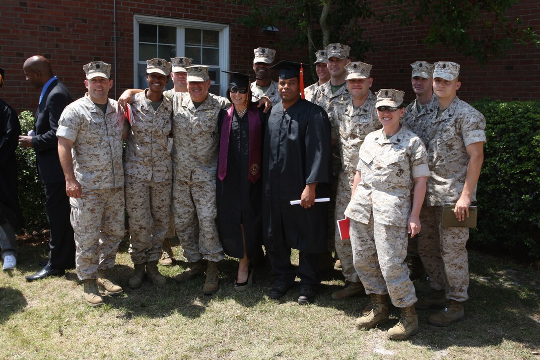 Petty Officers 1st Class Angela Warner (center left) and Julianny Acosta, instructors with the Field Medical Training Battalion aboard Camp Johnson, stand in their graduate attire with command personnel of the FMTB after receiving their college diplomas after the 16th Annual Commanding Officer’s Graduation Ceremony at the Marine Corps Base Camp Lejeune theatre, June 3. Eight colleges with branch offices at the Lejeune Education Center aboard the base graduated nearly 100 students during the ceremony, 722 service members and civilians graduating overall.