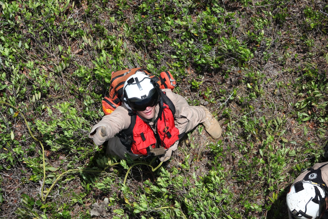 Gunnery Sgt. John P. Vinlove waits for a simulated casualty gets lifted off of the ground in the Croatan National Forest during the Marine Transport Squadron 1 search and rescue certification testing June 3. “Every time I get a chance to conduct training that gets me closer to certification is exciting and motivating,” said Vinlove. “Not only that but getting to fly with such a great group of Marines and Sailors in a mission to not only help the air station but protect the lives of eastern North Carolina in a different way than Marines usually do.”