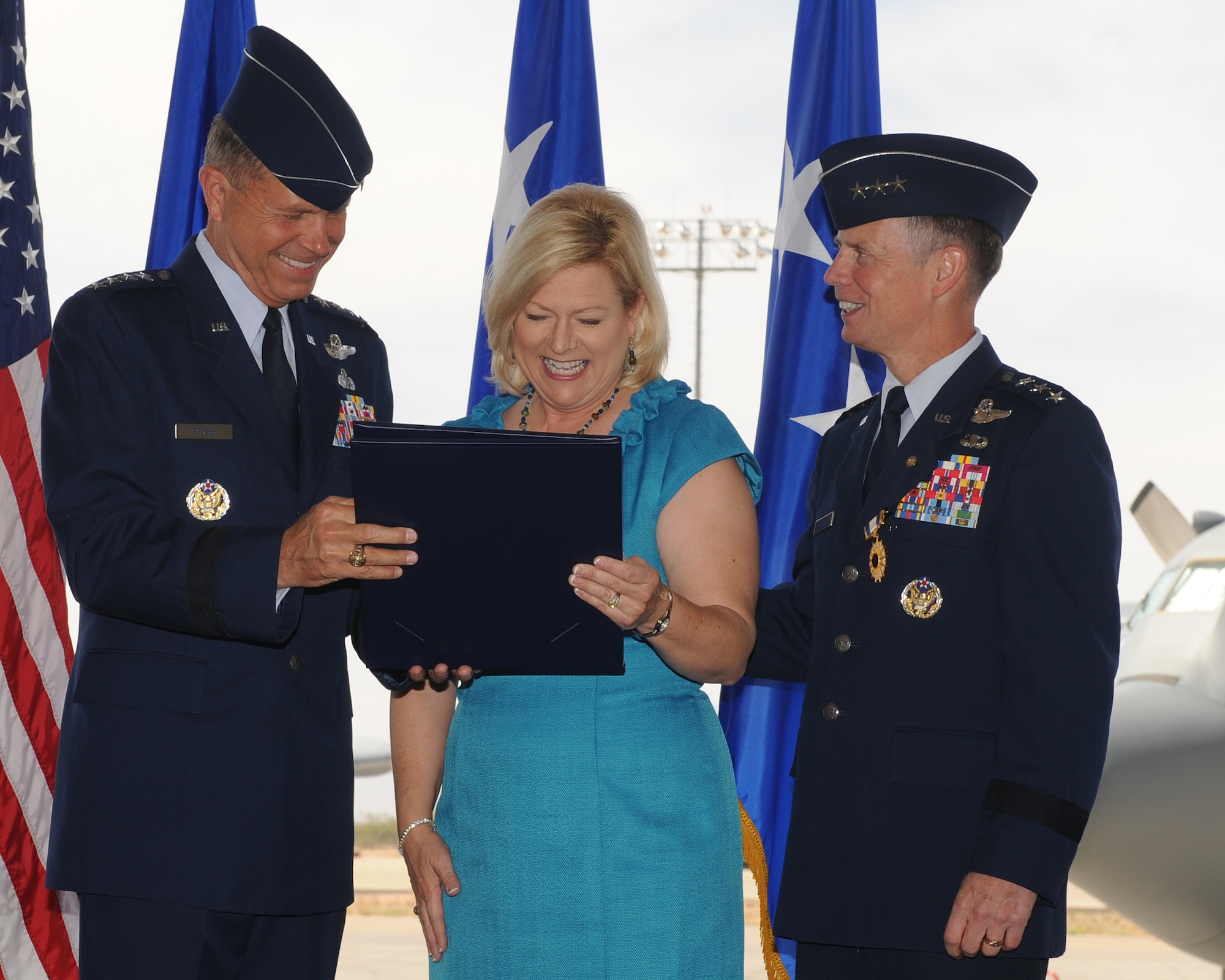 General William Fraser III (left), Air Combat Command commander, presents the Military Spouse Medal to Kim Spears, wife of Lt. Gen. Glenn Spears (right) during General Spears' retirement ceremony June 1 at Davis-Monthan Air Force Base, Ariz. (U.S. Air Force photo/Senior Airman Brittany Dowdle)