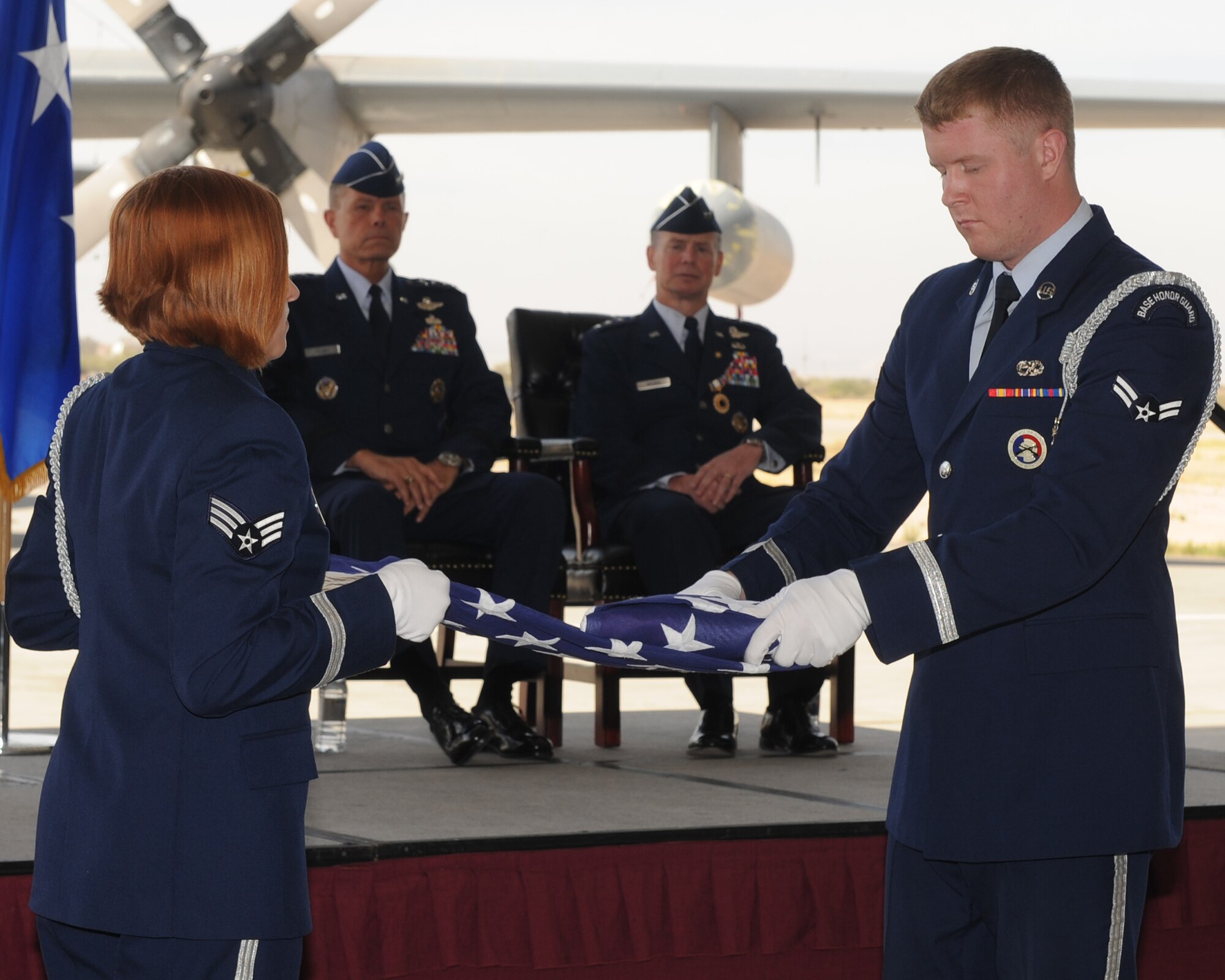 Lt. Gen. Glenn Spears (right background) watches the Davis-Monthan Air Force Base Honor Guard fold a flag during his retirement ceremony June 1. (U.S. Air Force photo/Senior Airman Brittany Dowdle)