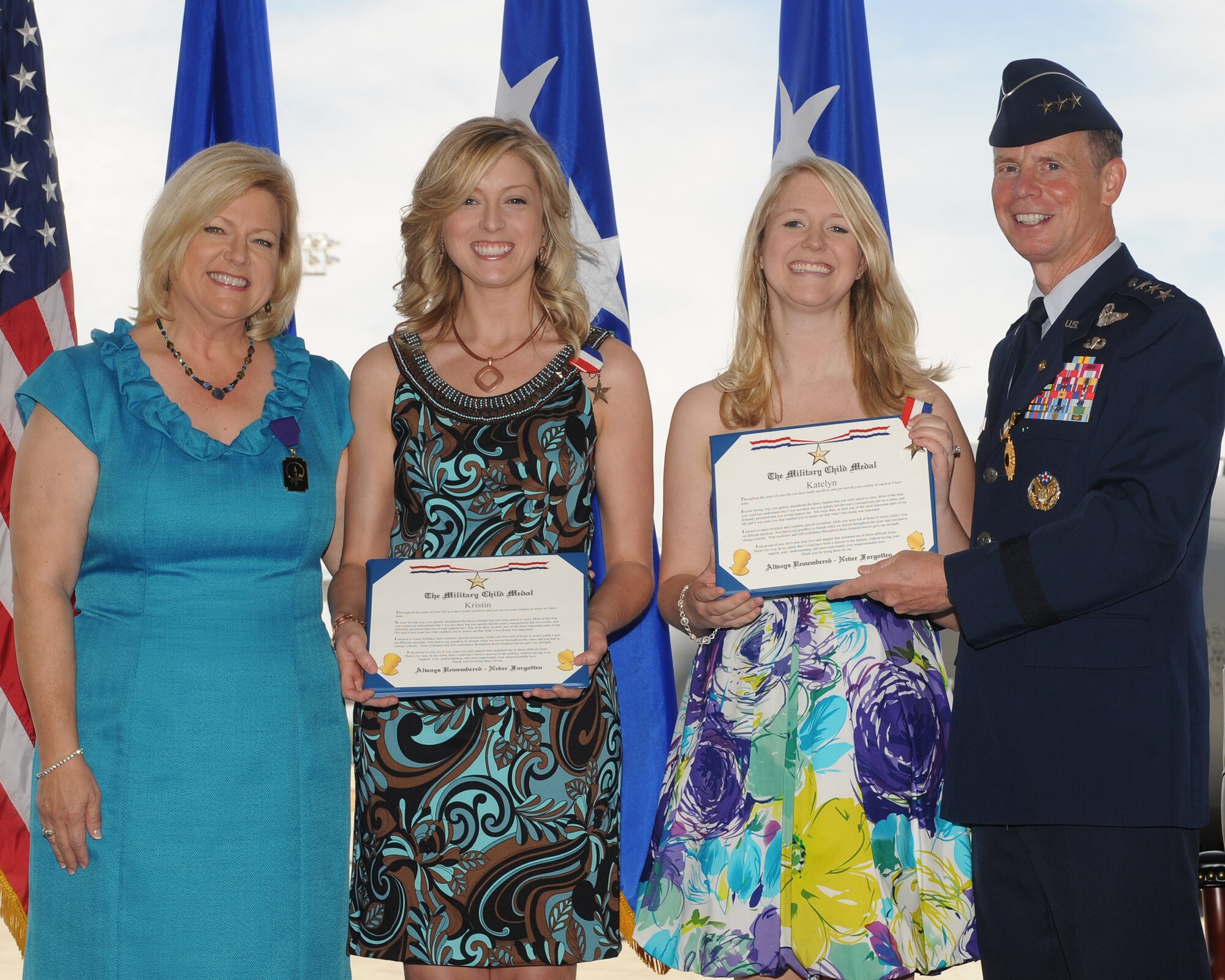 Lt. Gen. Glenn Spears (right) awards the Military Child Medal to his daughters Kristin and Katelyn alongside his wife Kim during his retirement ceremony June 1 at Davis-Monthan Air Force Base, Ariz. (U.S. Air Force photo/Senior Airman Brittany Dowdle)