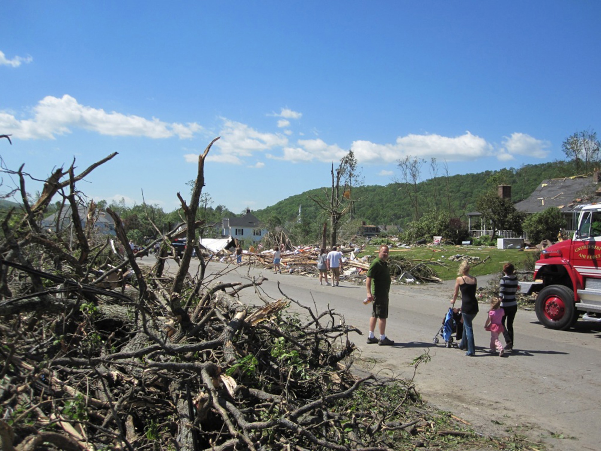 Residents of Monson, Mass., walk through their neighborhood after a tornado that ripped through the area June 1, 2011. Firefighters from Westover Air Reserve Base, Mass., performed search and rescue the next day in Monson after two tornadoes left widespread damage in 19 communities across the area. (Courtesy photo/Capt. Robert Mancini)