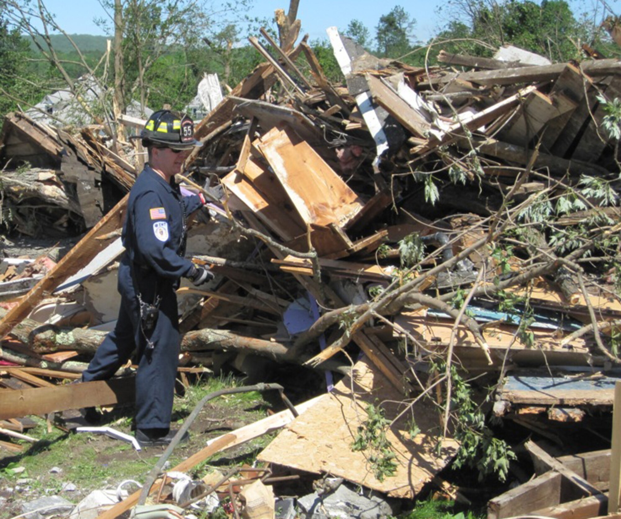 A firefighter from Westover Air Reserve Base, Mass., shifts through the rubble of a home in Monson, Mass., June 2, 2011. Volunteers from the base responded to a community mutual agreement to search for survivors after two tornadoes the day before left widespread damage in 19 communities across the area. (Courtesy photo/Capt. Robert Mancini)
					